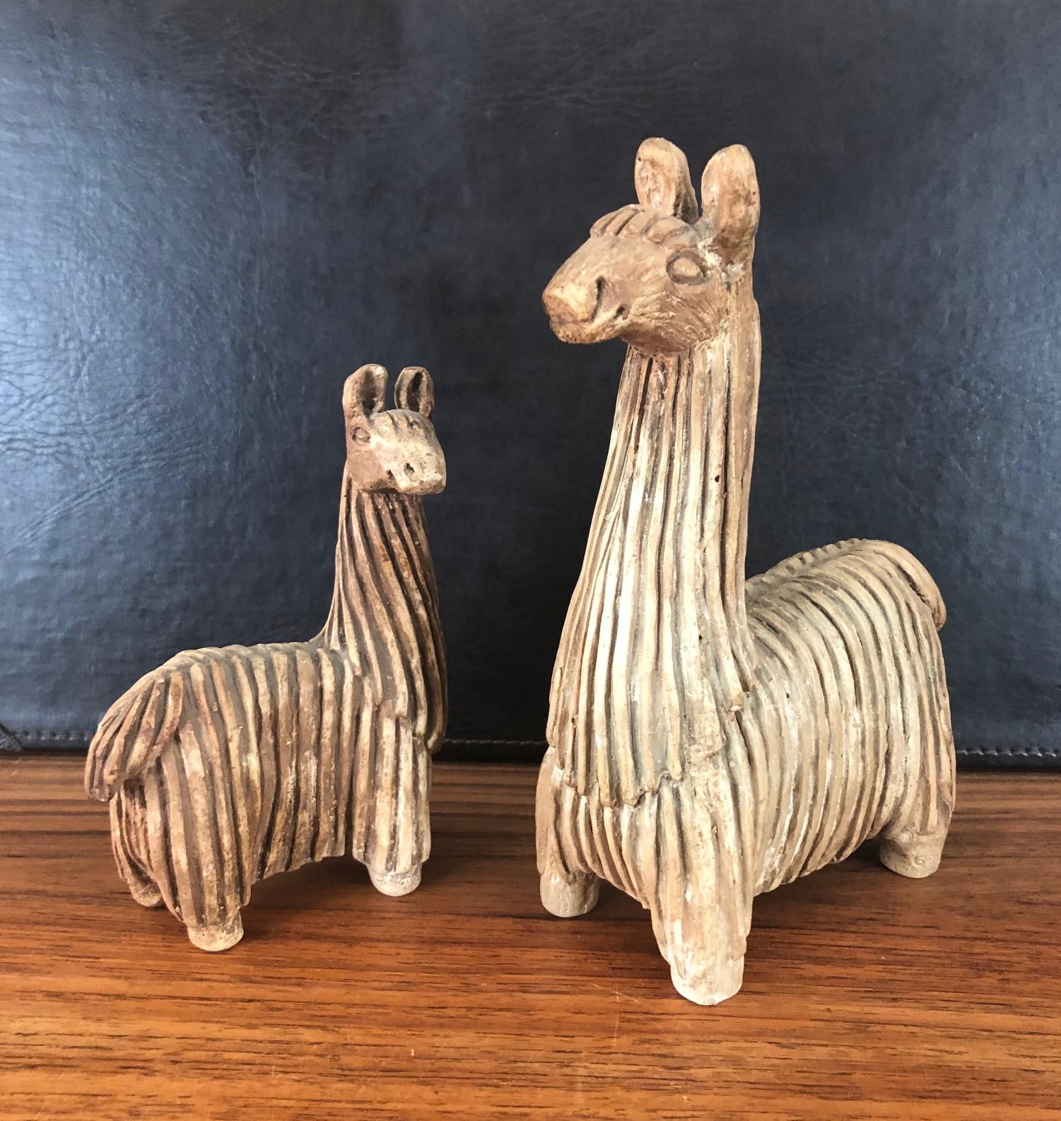 A very cool pair of midcentury stoneware llamas by Fabbri Art Co. of San Francisco, circa 1970s. Mother and baby llama have been beautifully sculpted with deep striking texture and glazed to bring them to a rich deep beige color.

Mother stands