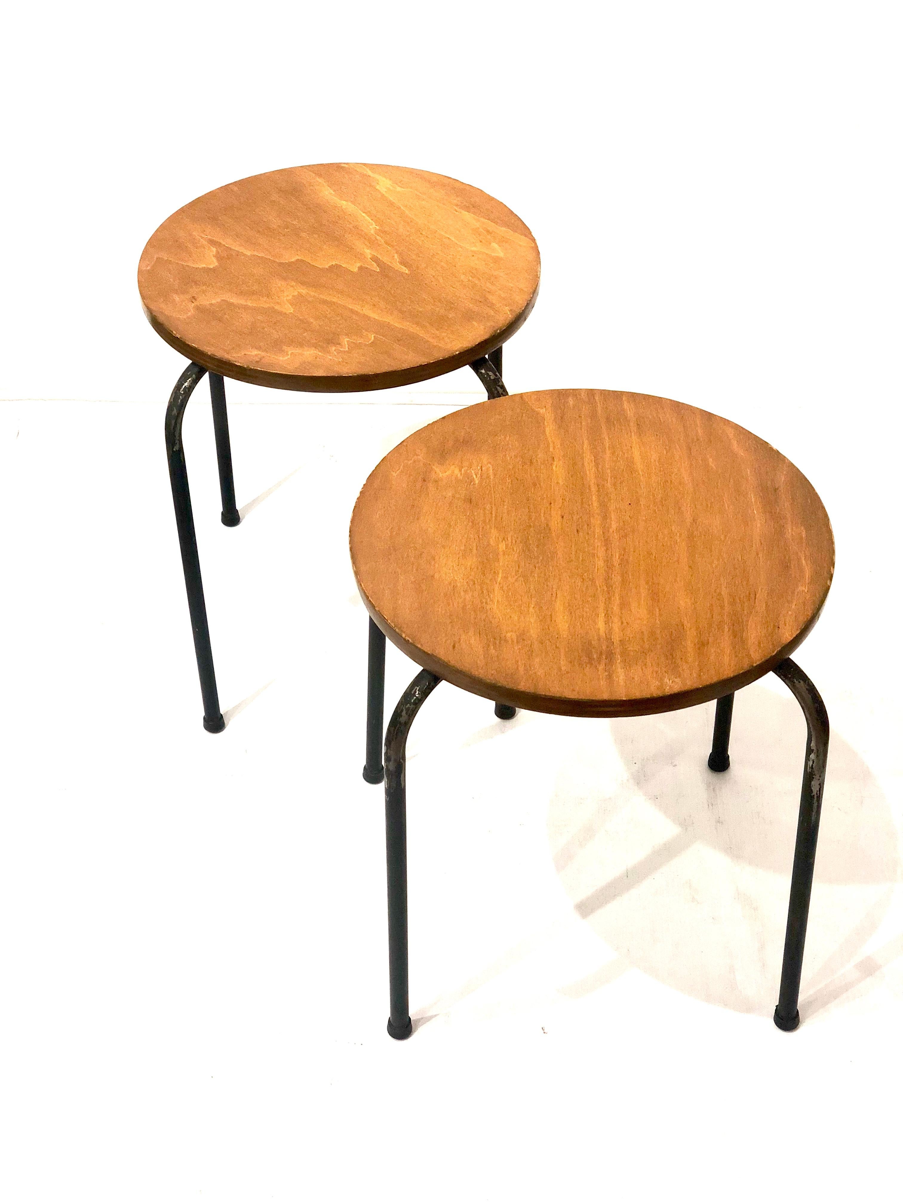 Cool pair of 1950s American midcentury atomic age stackable stools, on tubular metal legs and wood tops left in its original finish and condition we have clean them and oil them but they show normal wear due to age.