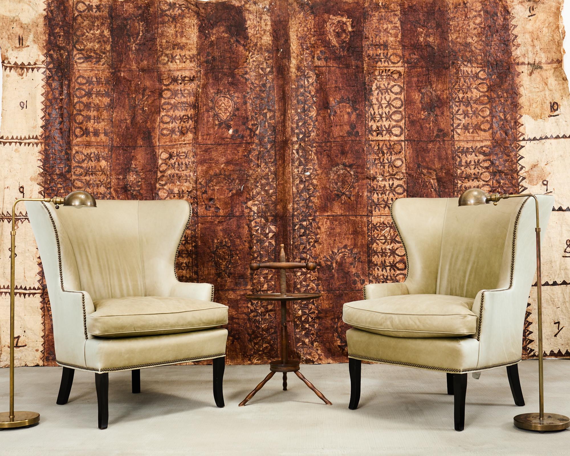 Beautifully weathered pair of leather butterfly wingback chairs made in the mid-century modern style by Williams-Sonoma. Hand-crafted in the USA featuring hardwood frames upholstered with Italian aniline distressed leather in a stylish olive green
