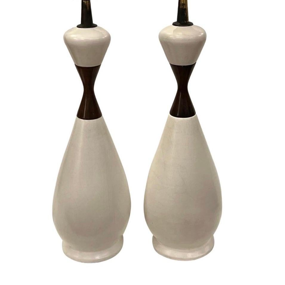 Pair of circa 1950's white porcelain and wood Swedish table lamps.

Measurements:
Height of body: 19