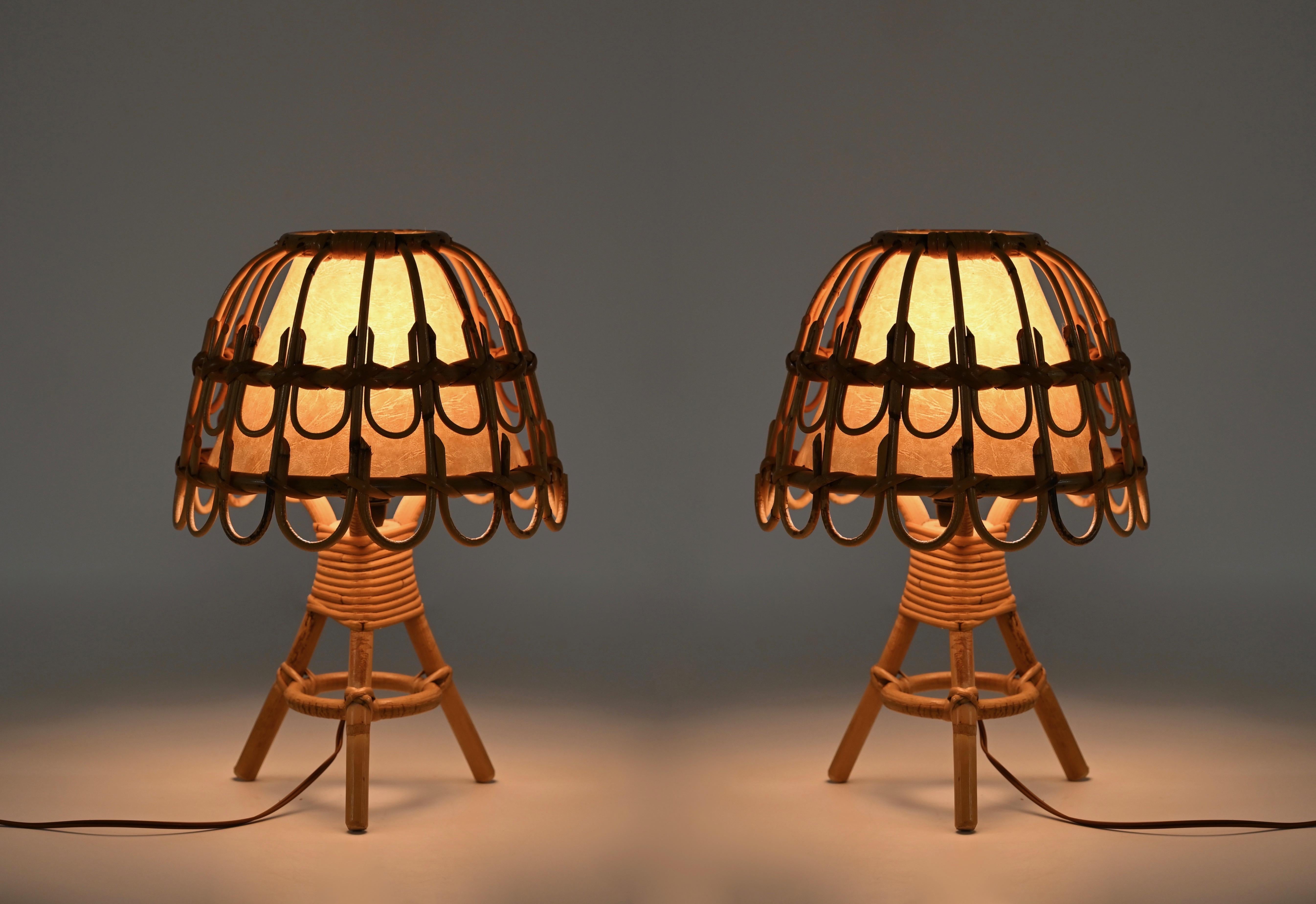 Gorgeous pair of Mid-Century French Riviera style table lamps made in curved rattan and hand-woven wicker. These fantastic lamps were made in France during the 1960s and are attributed to the mastery of Louis Sognot.  

The lamps are a clear example