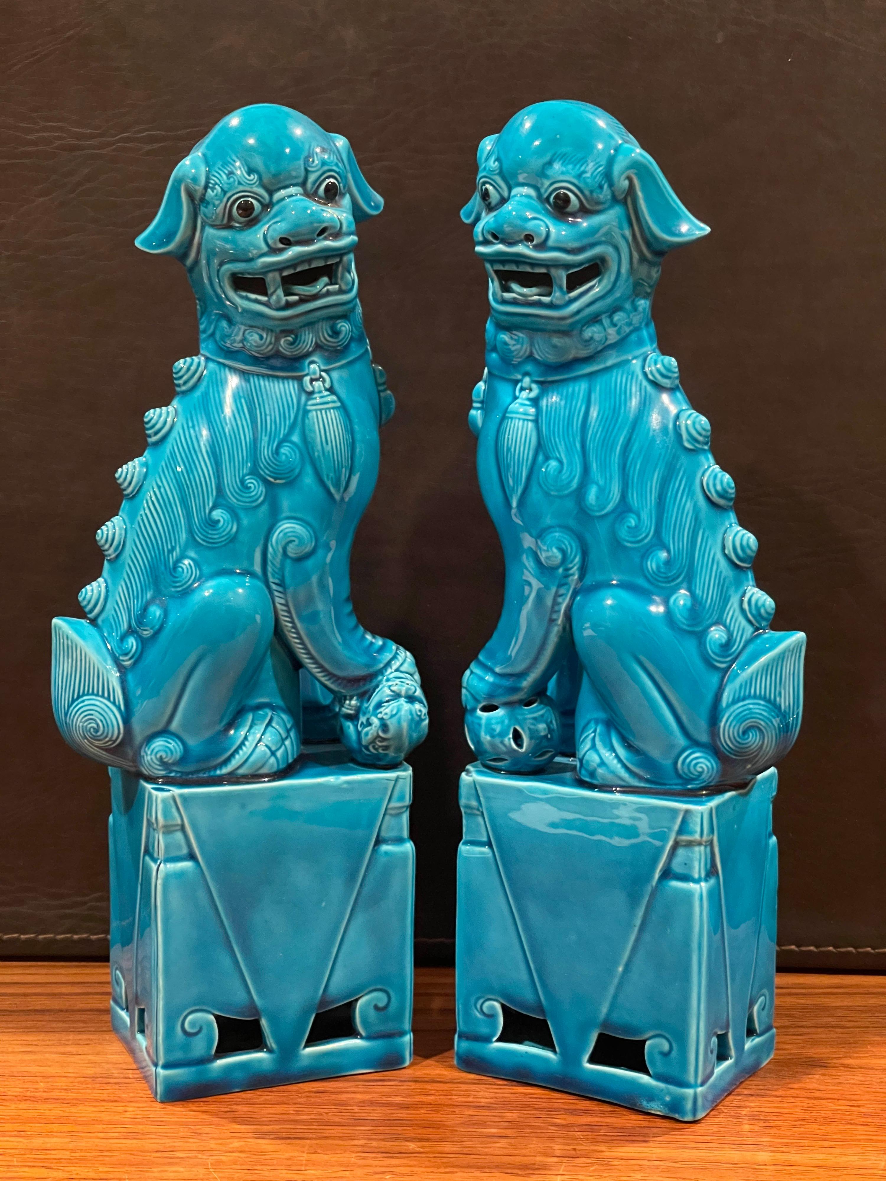 Excellent pair of mid-century turquoise blue ceramic foo dog sculptures, circa 1960s. These symbolic guardians present a beautiful turquoise hue and are in very good vintage condition with no chips or cracks. The dogs measure 9.5