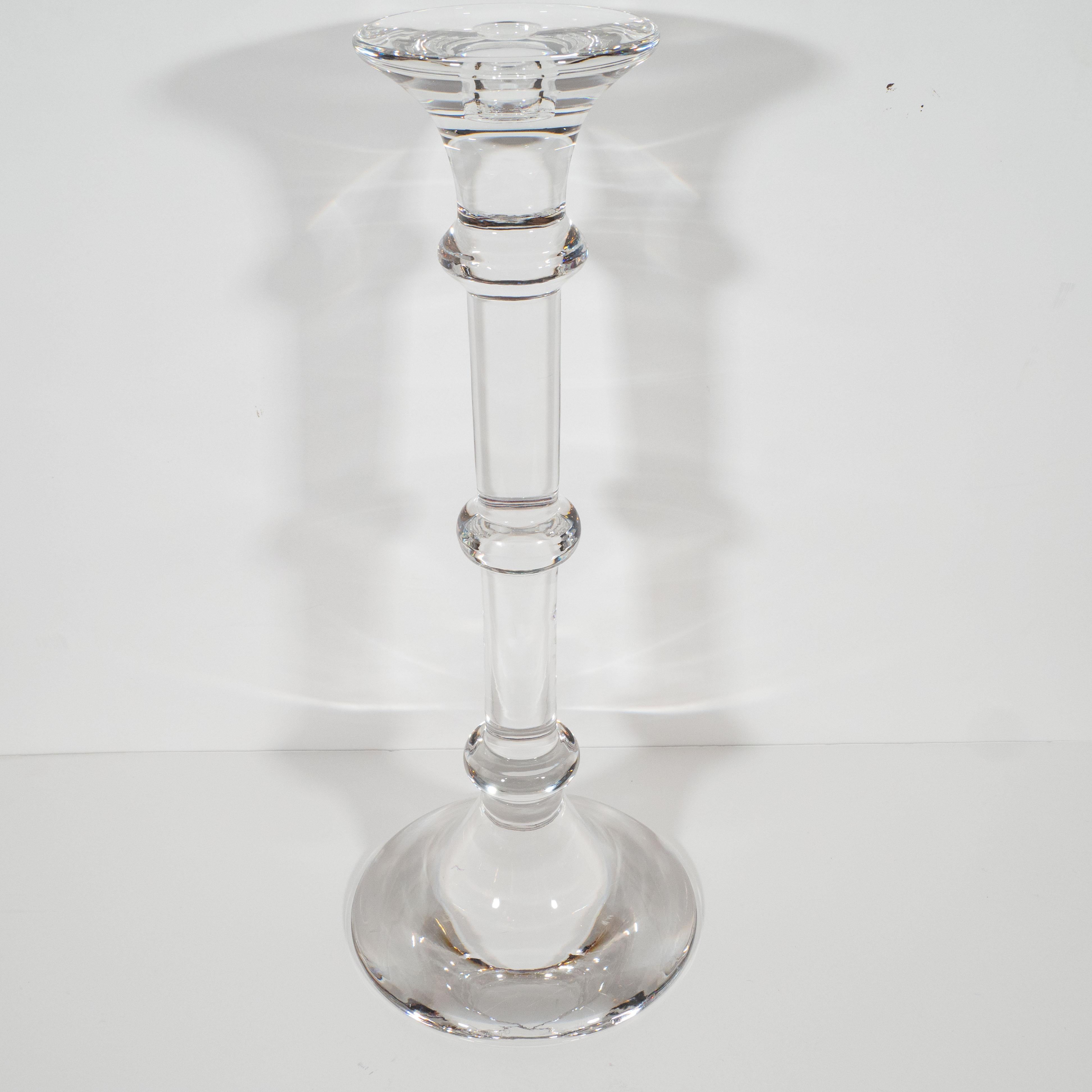 This stunning pair of candlesticks was realized by the esteemed Belgian crystal studio- Val Saint Lambert, circa 1970. It features a Doric column-form- with three rings circumscribing a cylindrical body- handblown from translucent crystal that