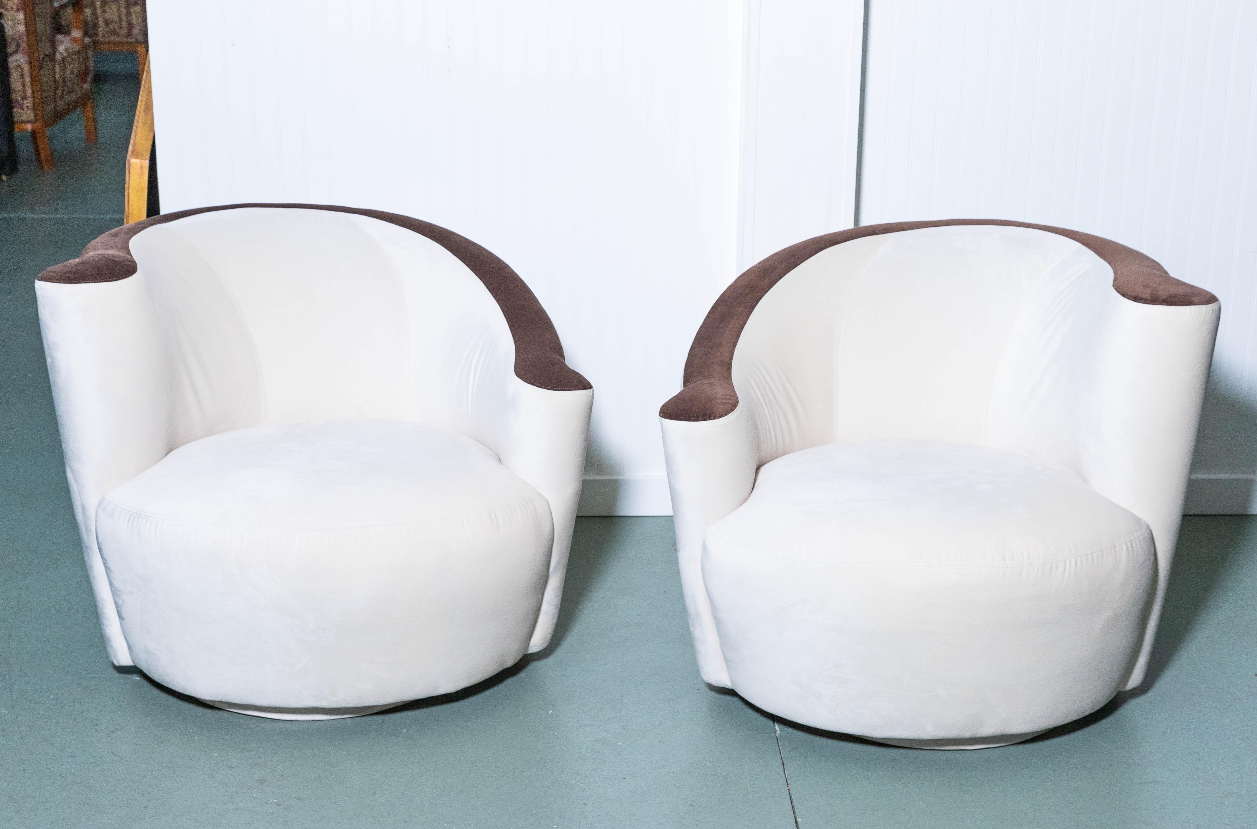 Pair of Vladimir Kagan Nautilus swivel chairs, newly upholstered in cream and chocolate ultrasuede for Weiman. LUX with curved top sides and seat. True deco style.