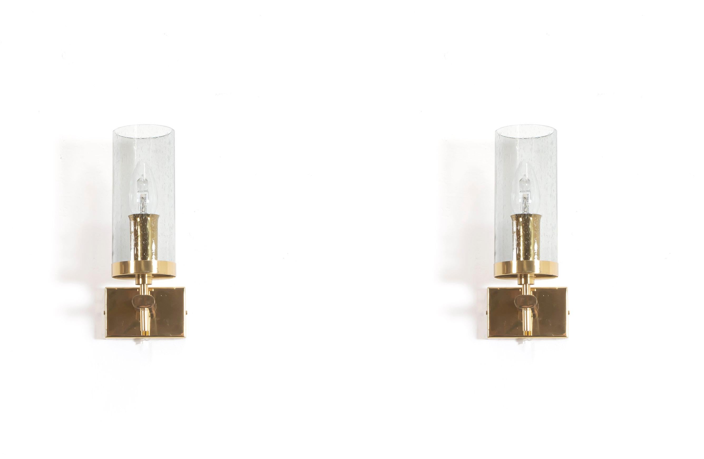 Decorative wall lights in brass and shades in smoked glass. Designed and made in Norway by Bison from circa 1970s first half. Both lamps are fully working and in very good vintage condition. The lamps are using an E14 bulb with a max wattage of 40.