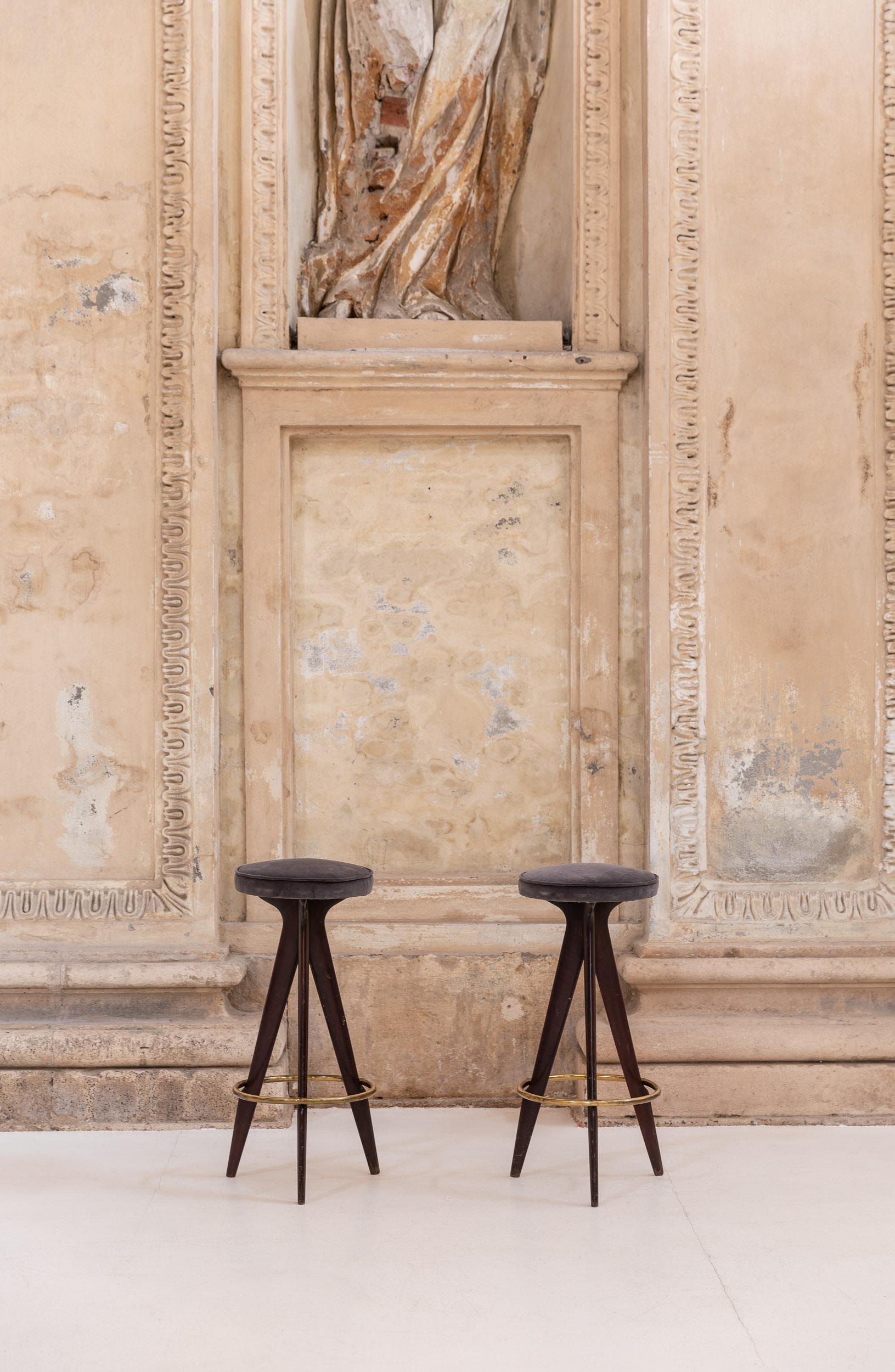 Pair of stool with walnut legs, velvet and brass accents, attributed to Ico Parisi.
The frame of the stool is executed in brown wood, the round seat are upholstered in grey velvet, the ring that connects the three legs is made in golden