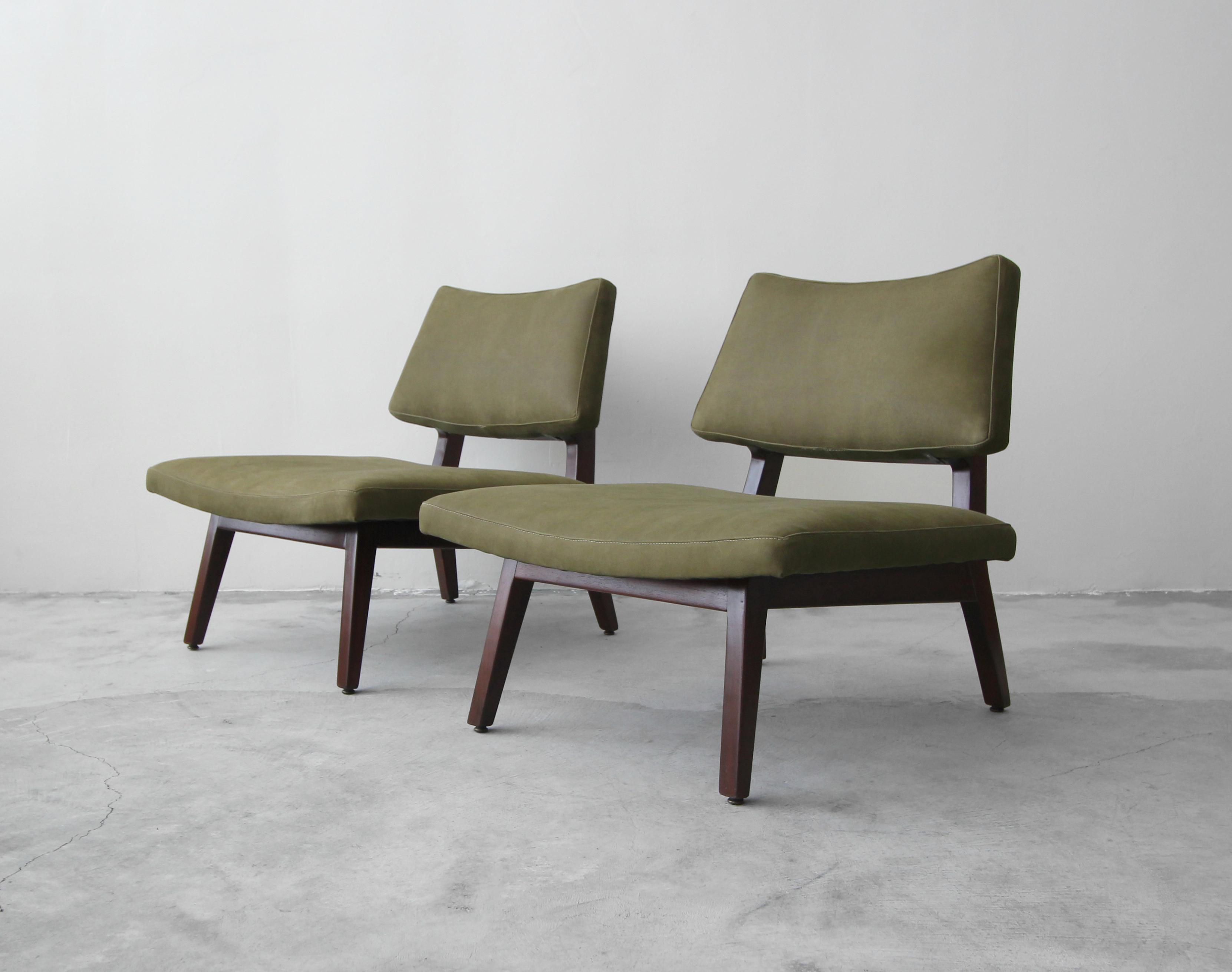 Stunning pair of sculpted side chairs by Jens Risom. A gorgeous pair of midcentury slipper style chairs with oversized seats, great curved lines and sculptural, solid walnut frames.

Professionally reupholstered in a beautiful olive green leather.