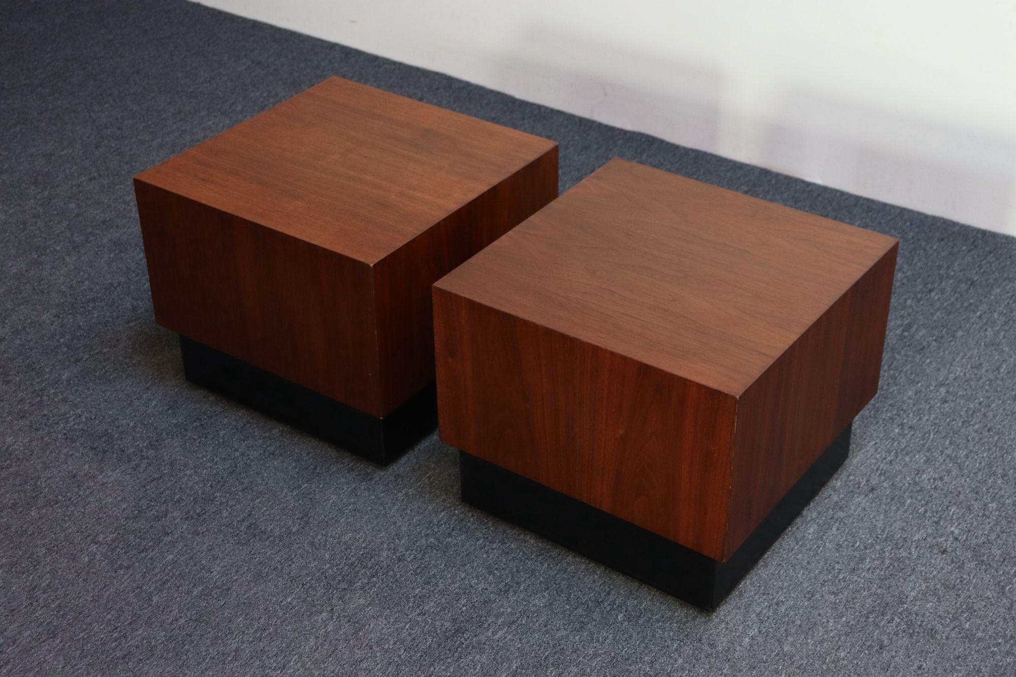 Low, cube end / side tables in walnut with an ebonized plinth-base (circa 1960s, USA).
Finished on all sides, each with different walnut grain.
Refinished condition; only minor wear remains (one small repair to replace a spot of veneer loss along