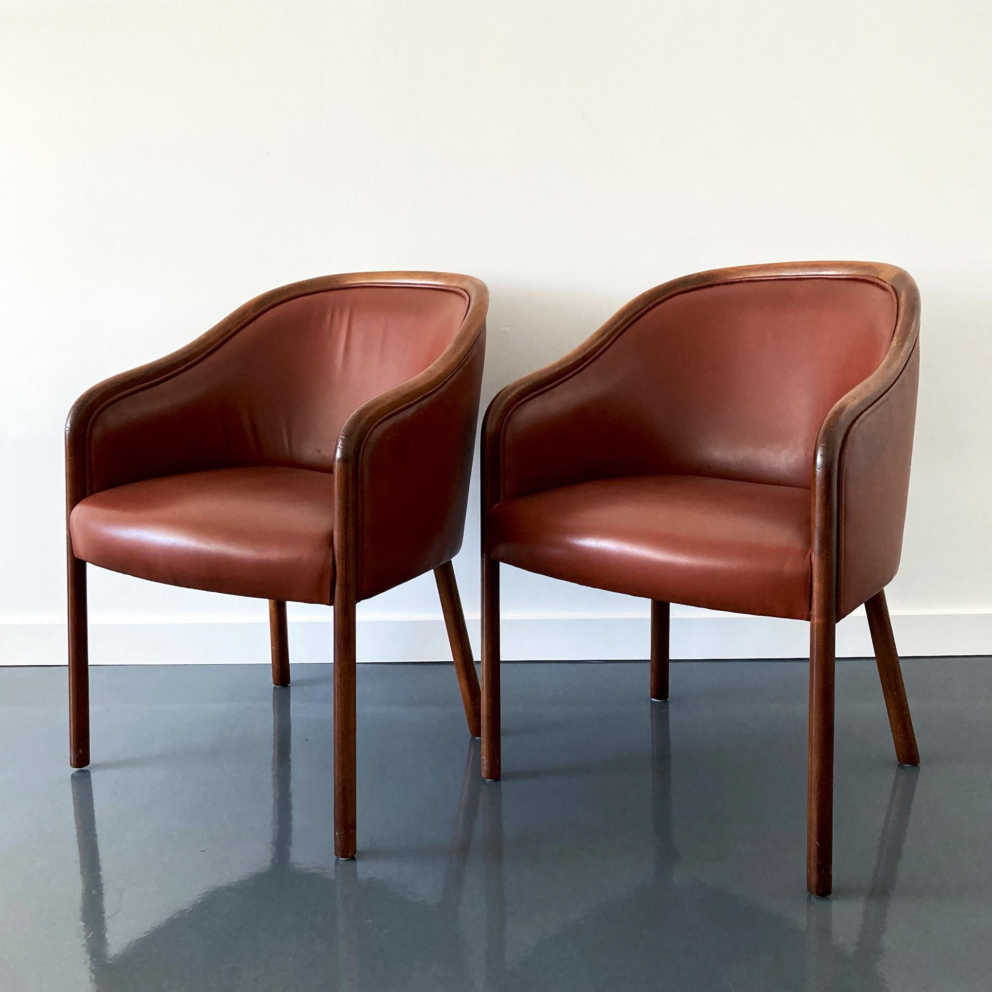 Designed by Ward Bennett for Brickel Associates, elegant leather armchairs. Made from ash wood and stained in a walnut finish, upholstered in burgundy leather. Stunning pair of chairs, leather is in good condition. The chairs are structurally sound