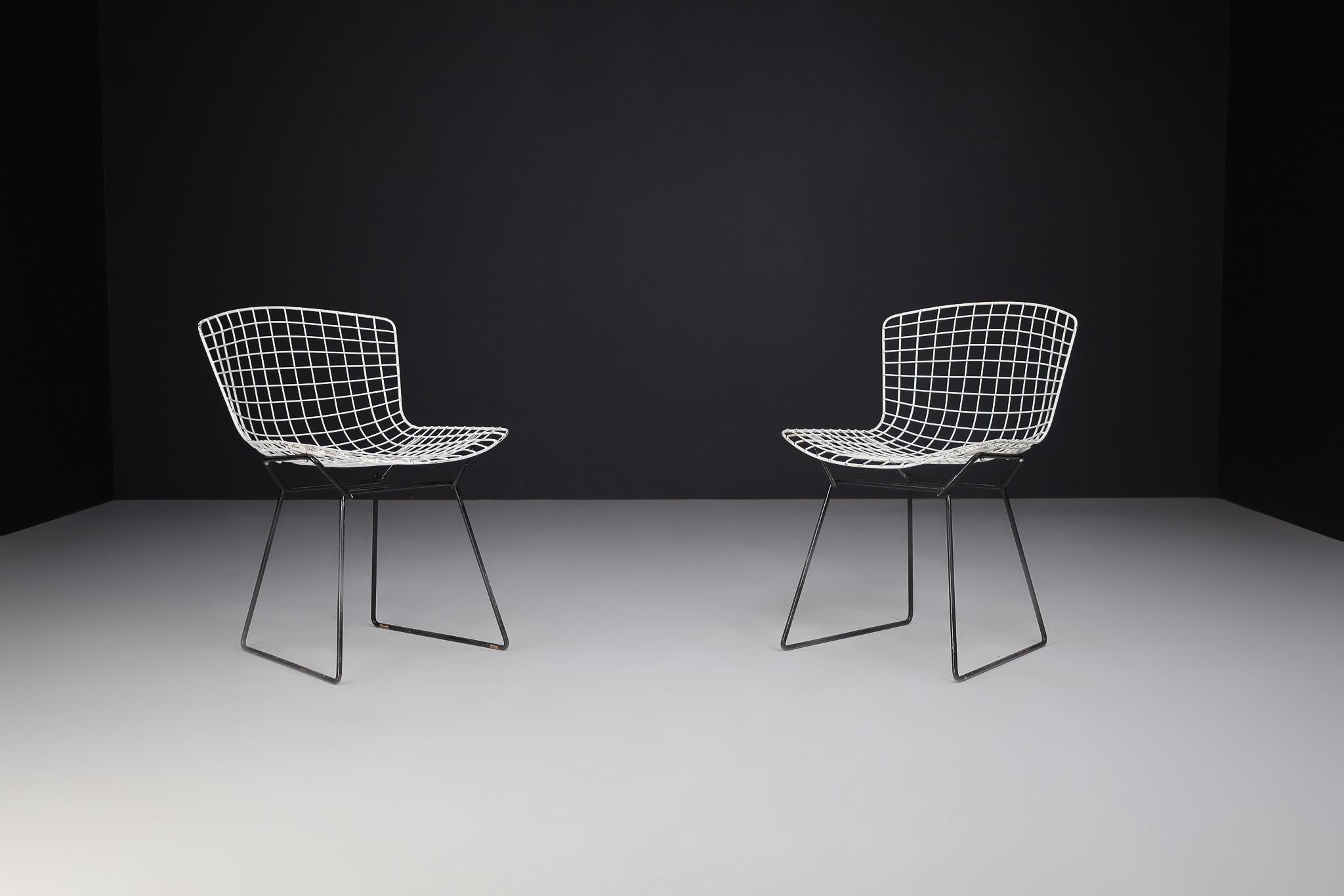 This pair of Bertoia side chair is composed of delicate steel rods that have been precisely interwoven and welded to create airy, sculptural seats. Despite their delicate filigreed appearance, the chairs are supremely strong. 

More information
