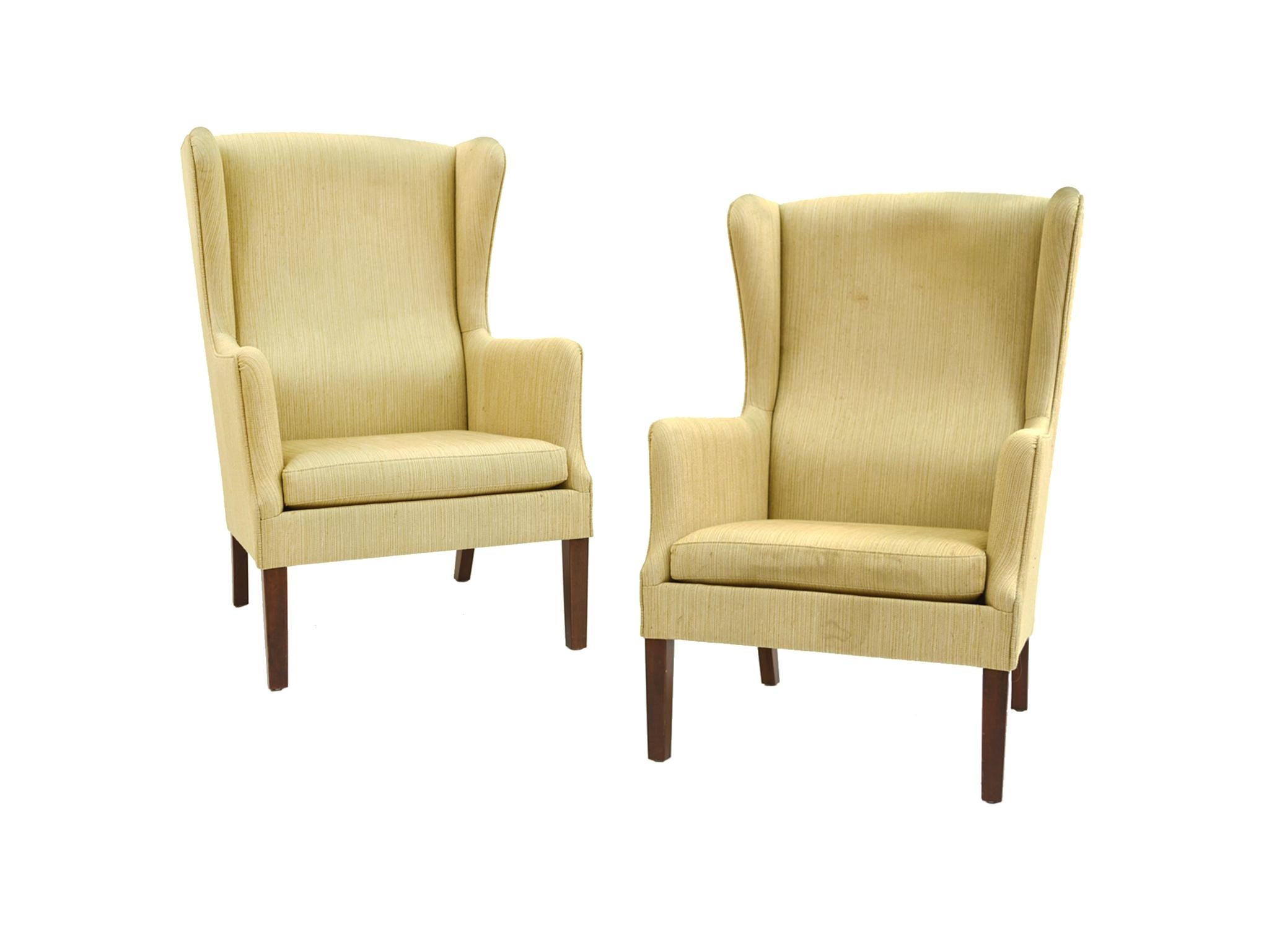 A pair of Classic wingback armchairs designed with a modern touch. Manufactured mid-20th century and attributed to Danish architect and designer Peter Hvidt. Clean, smooth lines and rounded edges characterize the chairs' elegant and warm design. The
