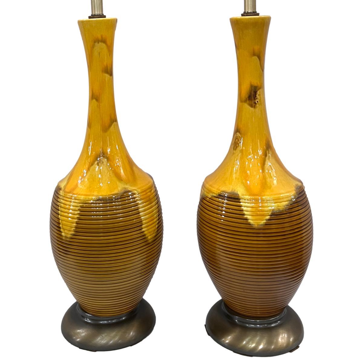 Coppia di lampade da tavolo in ceramica italiana degli anni '60 circa con finitura a smalto giallo.

Misure:
Altezza del corpo: 27,5
Altezza del paralume: 37.5