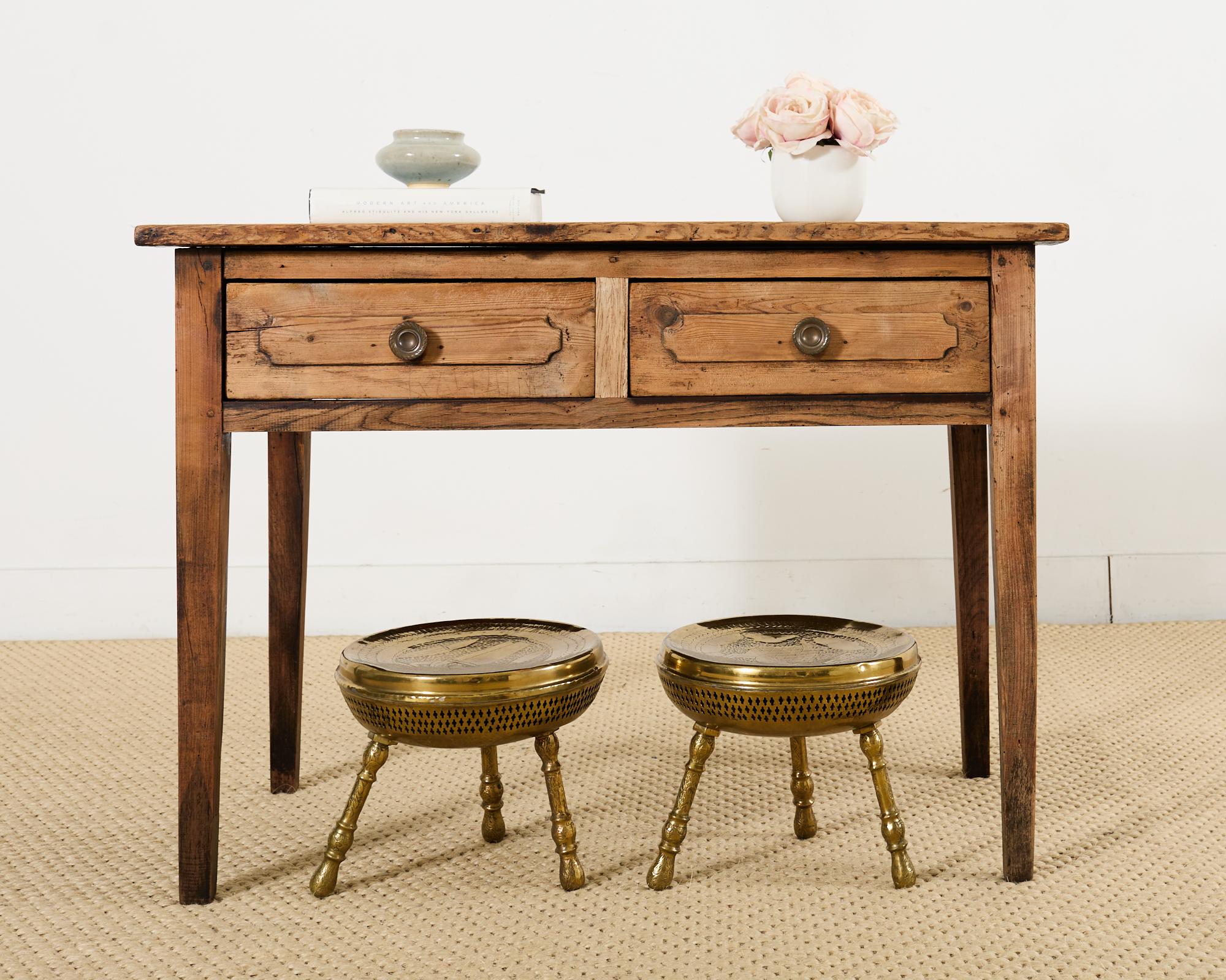 Paire de tabourets en laiton de style moyen-oriental à trois pieds, à décor ajouré. Les tabourets de style mauresque ont un siège concave avec des images gravées à la main d'un chameau sur l'un des tabourets et d'un profil d'homme sur l'autre. La