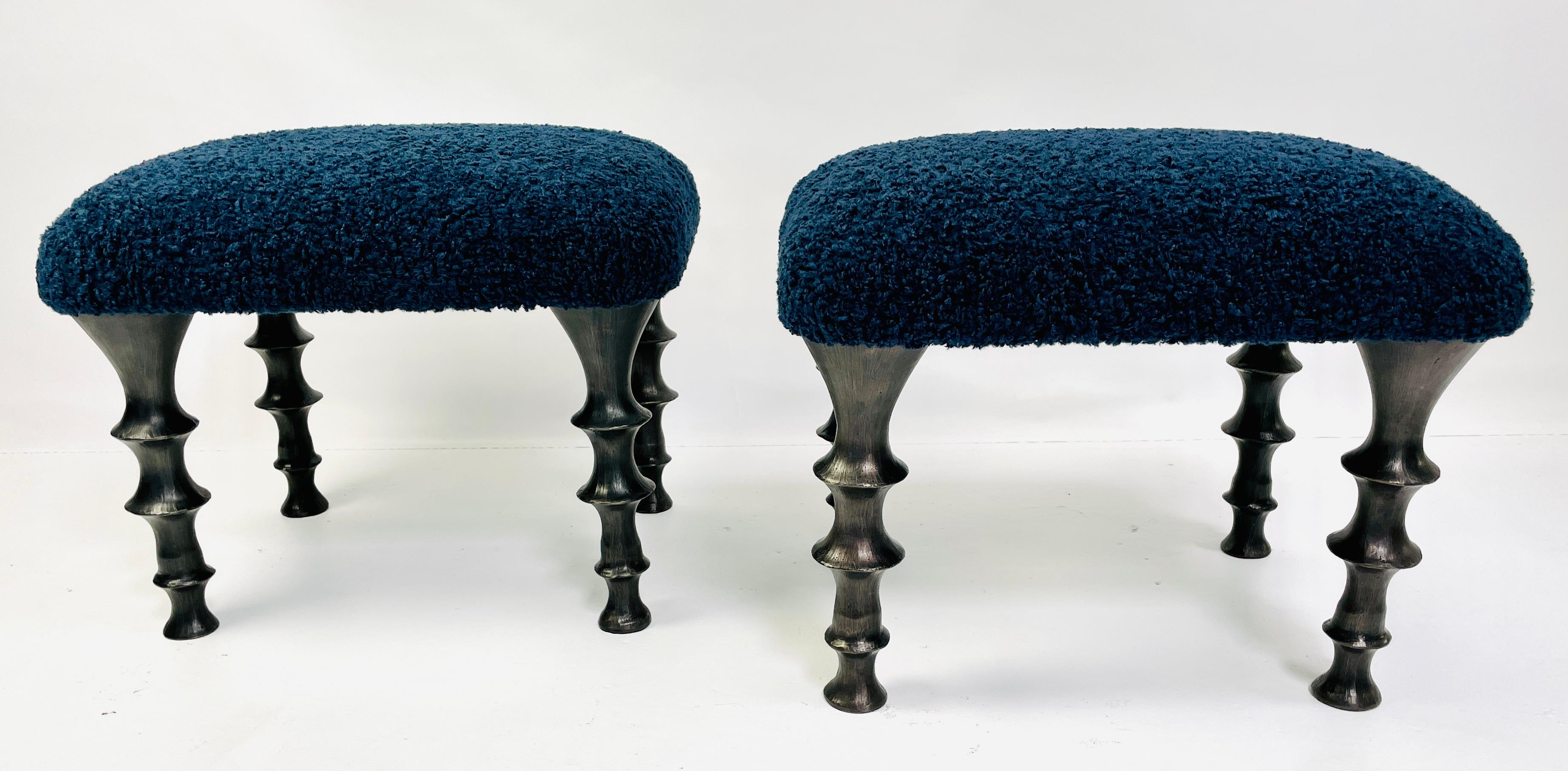 Two stools with cast bronze legs and midnight blue bouclé cushions. The design of the legs have an organic texture. These stools will make a powerful statement in your interior.