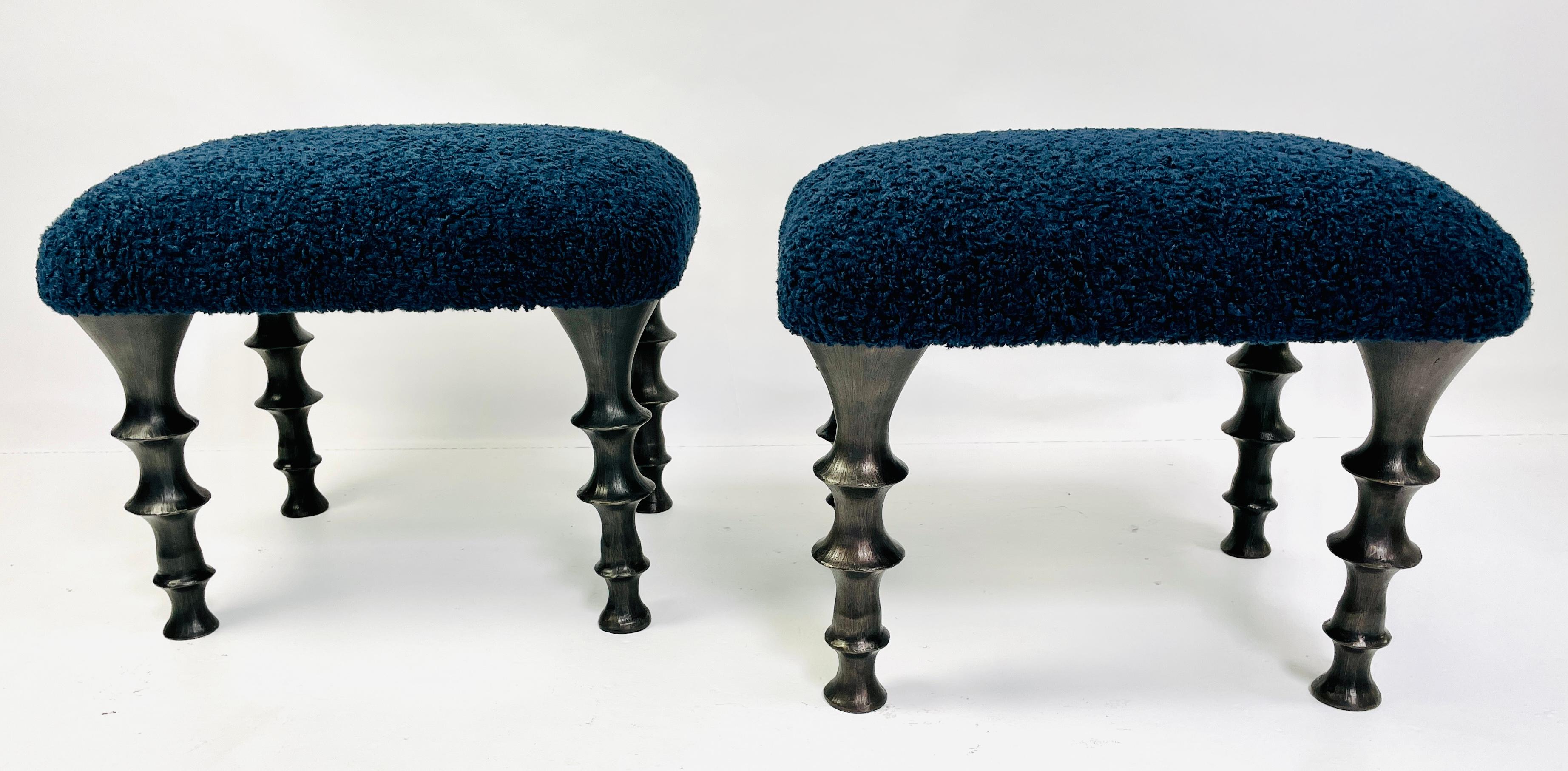 Deux tabourets avec pieds en bronze moulé et coussins en bouclette bleu nuit. Le design des pieds présente une texture organique. Ces tabourets feront une entrée remarquée dans votre intérieur.