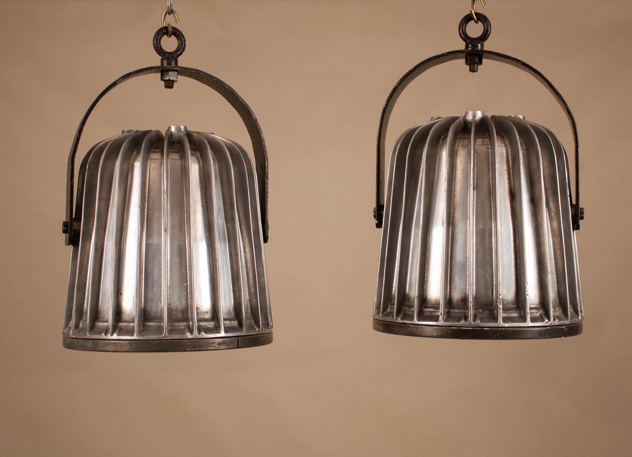 Trés cool pair of vintage aluminum Industrial pendant lights with tempered glass lenses. Manufactured by CEAG, Germany in the 1960s, these explosion-protected floodlights were likely salvaged from a ship- or dockyard. Like many marine lights, the