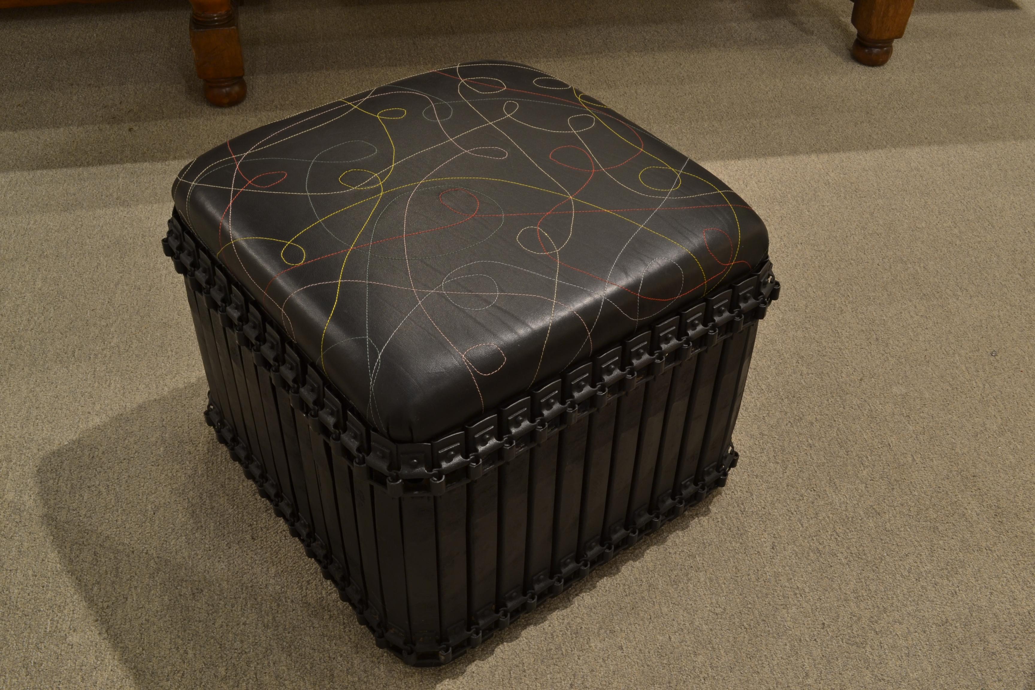 Our popular rust belt ottoman in a smaller, square shape with a blackened base. Shown in custom stitched leather.

These pieces can also be customized in the COL or COM of your choosing. Due to the nature of the old metal used, some variation in