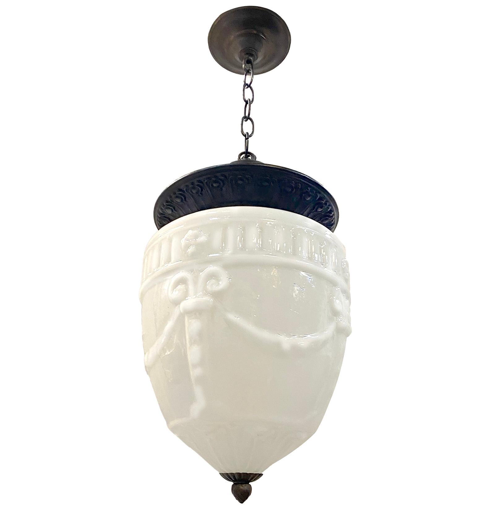 Pair of circa 1900 English molded milk glass English lanterns with column and garland motif, original hardware and interior light. Sold individually.

Measurements:
Current drop: 20