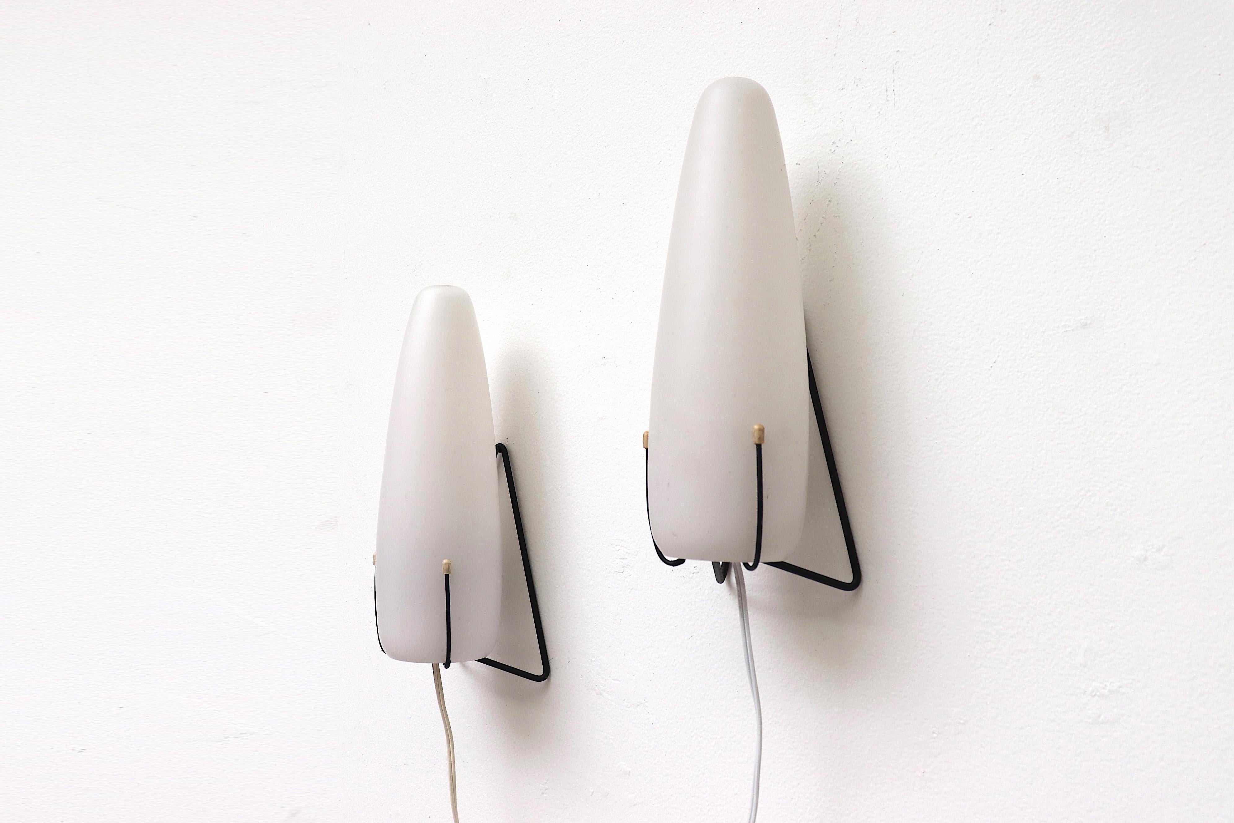 Pair of black enameled metal wire wall mount sconces with egg shaped milk glass shades. In original condition with original hardware and new plug. Set price. A similar set is available with decorative glass shades.