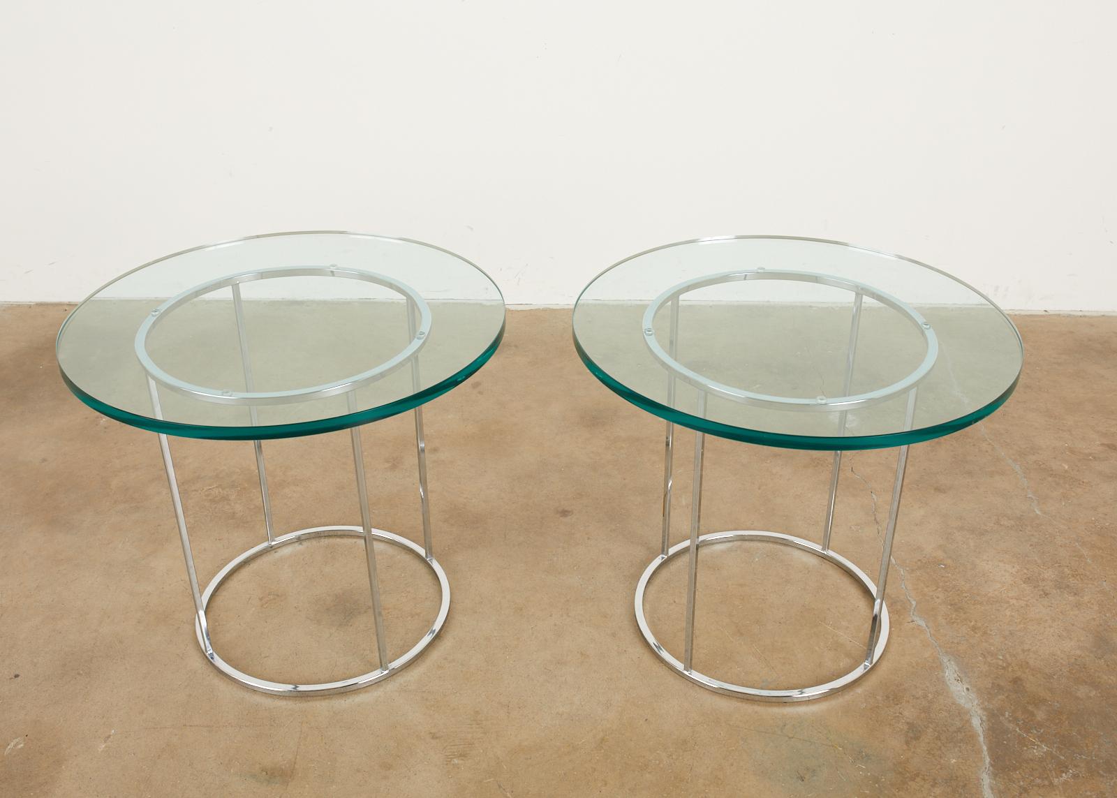 Stylish pair of mid-century modern chrome drinks tables attributed to Milo Baughman. The steel round frames feature Milo's iconic thin line profile design with a lovely chrome finish. Topped with thick round panes of glass. From an estate in