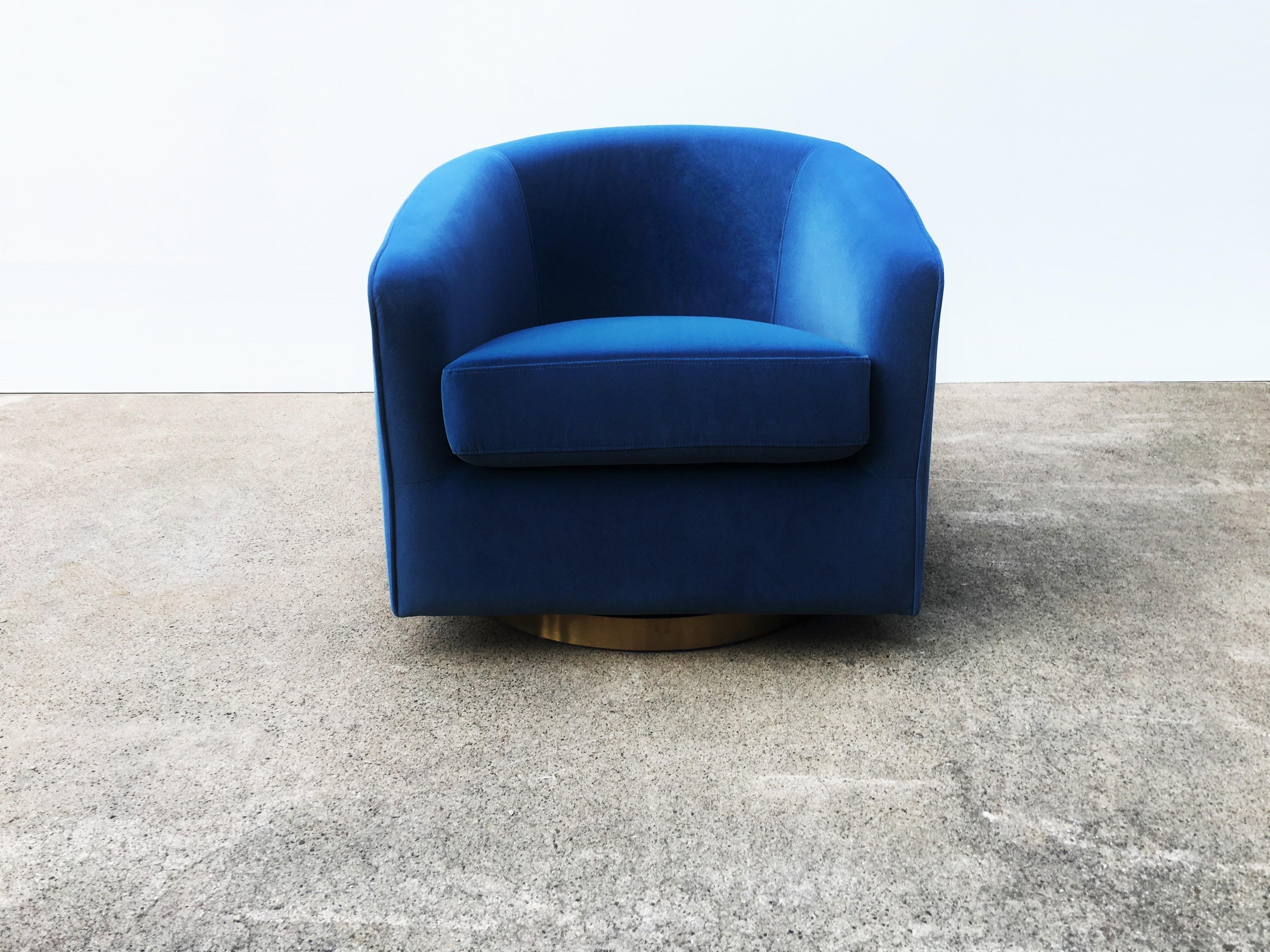Very well crafted club chairs designed by Milo Baughman. Featuring barrel shaped frames upholstered in blue velvet on swivel brass bases. The chairs have been expertly restored and reupholstered.