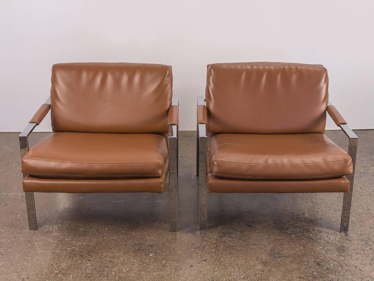 Pair of 1980s Milo Baughman Cognac lounge chairs. In excellent vintage condition. Cushions are robust and comfortably plump. Cognac leatherette is clean and supple with no rips or tears. Sleek flat-bar chrome supports the relaxed, low-slung form. A