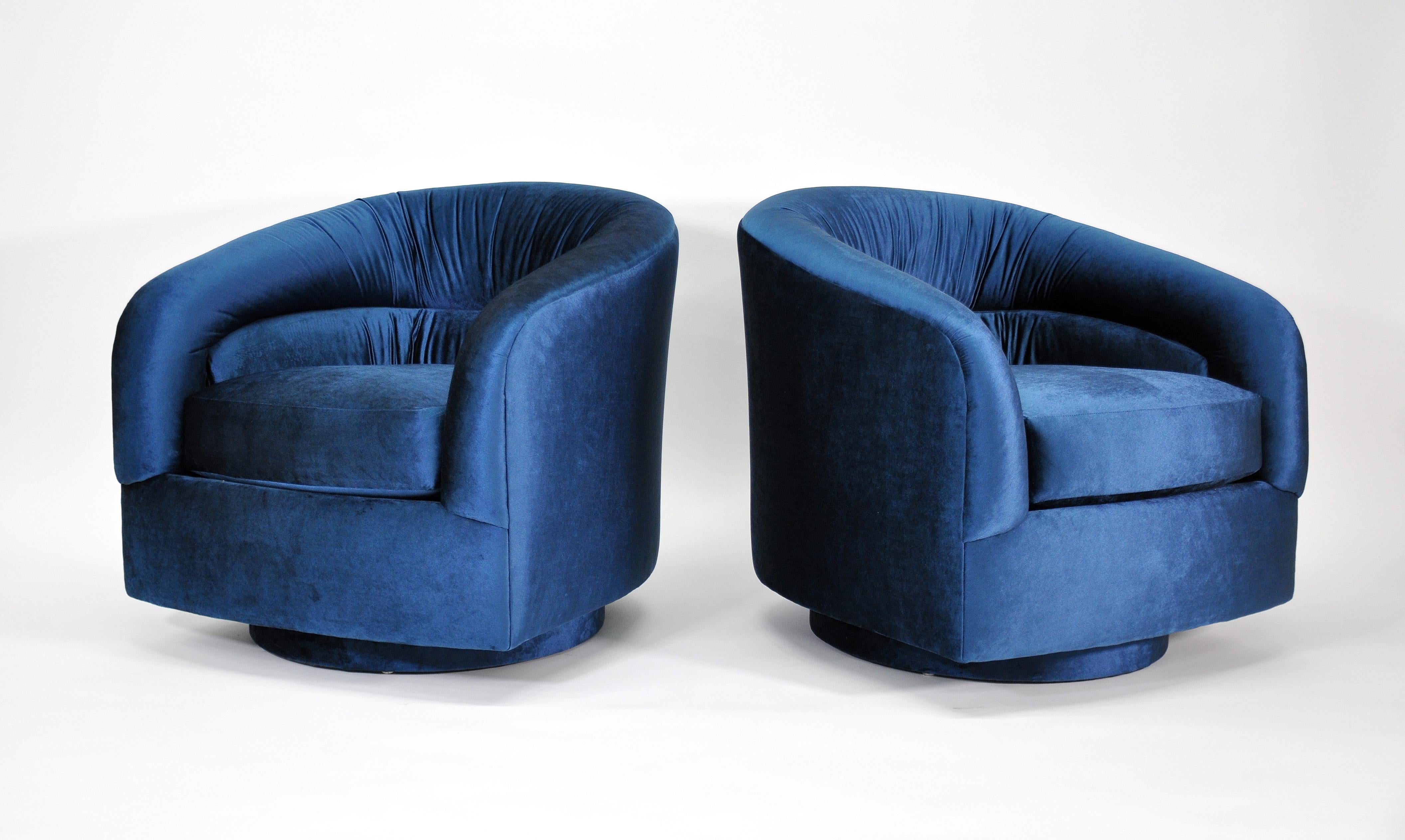 A fabulous pair of Mid-Century Modern barrel back swiveling club chairs, designed by Milo Baughman for Thayer Coggin, dating from the 1970s. Reupholstered in a luxurious and rich sapphire or navy blue jewel tone velvet, features an upholstered base