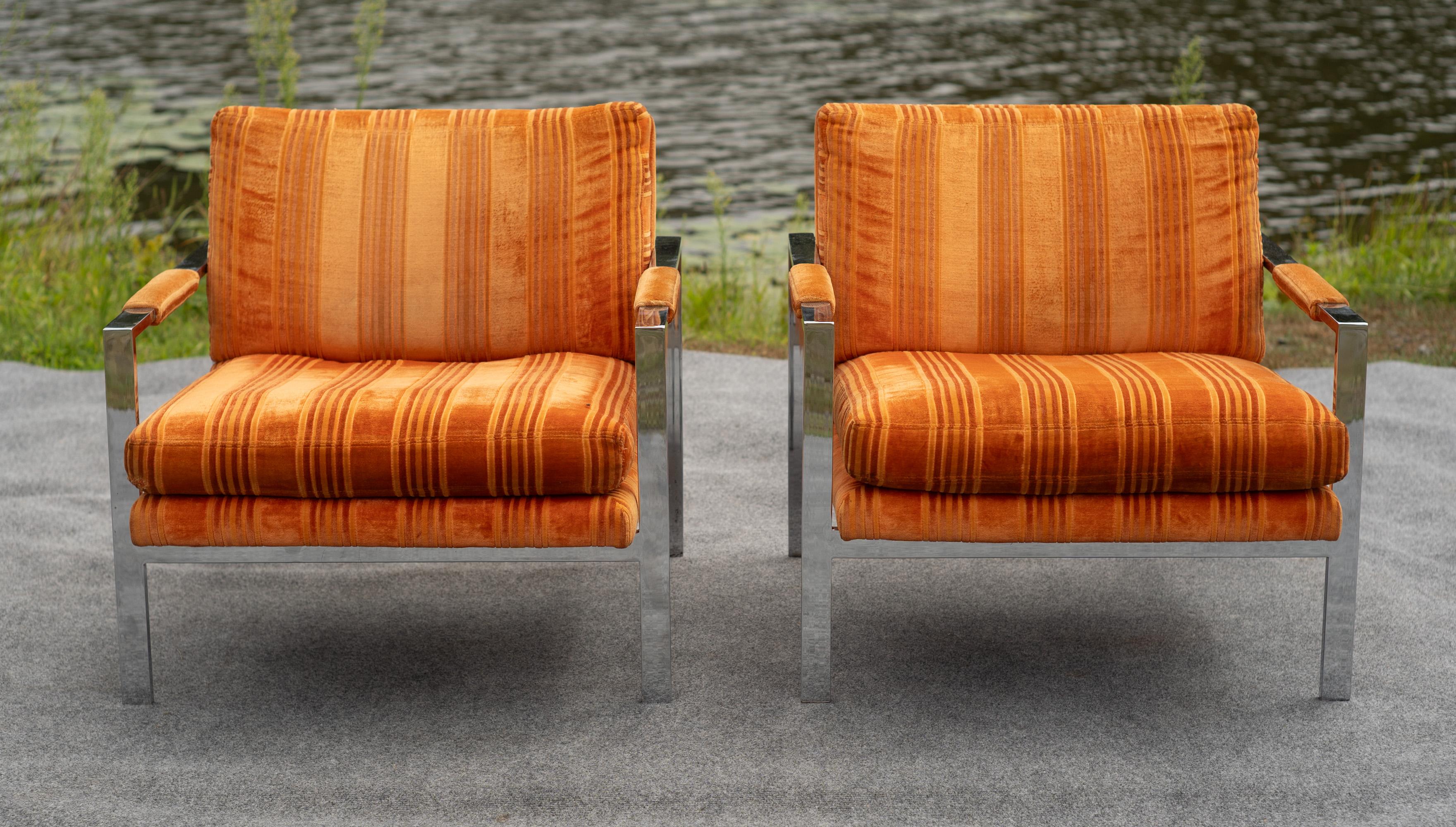 A matching pair of lounge chairs designed by Milo Baughman and produced by Thayer Coggin. Each chair features a frame of welded flat bar steel, finished with a chrome plating, protecting it from corrosion and rust. Upholstered in original Jack Lenor