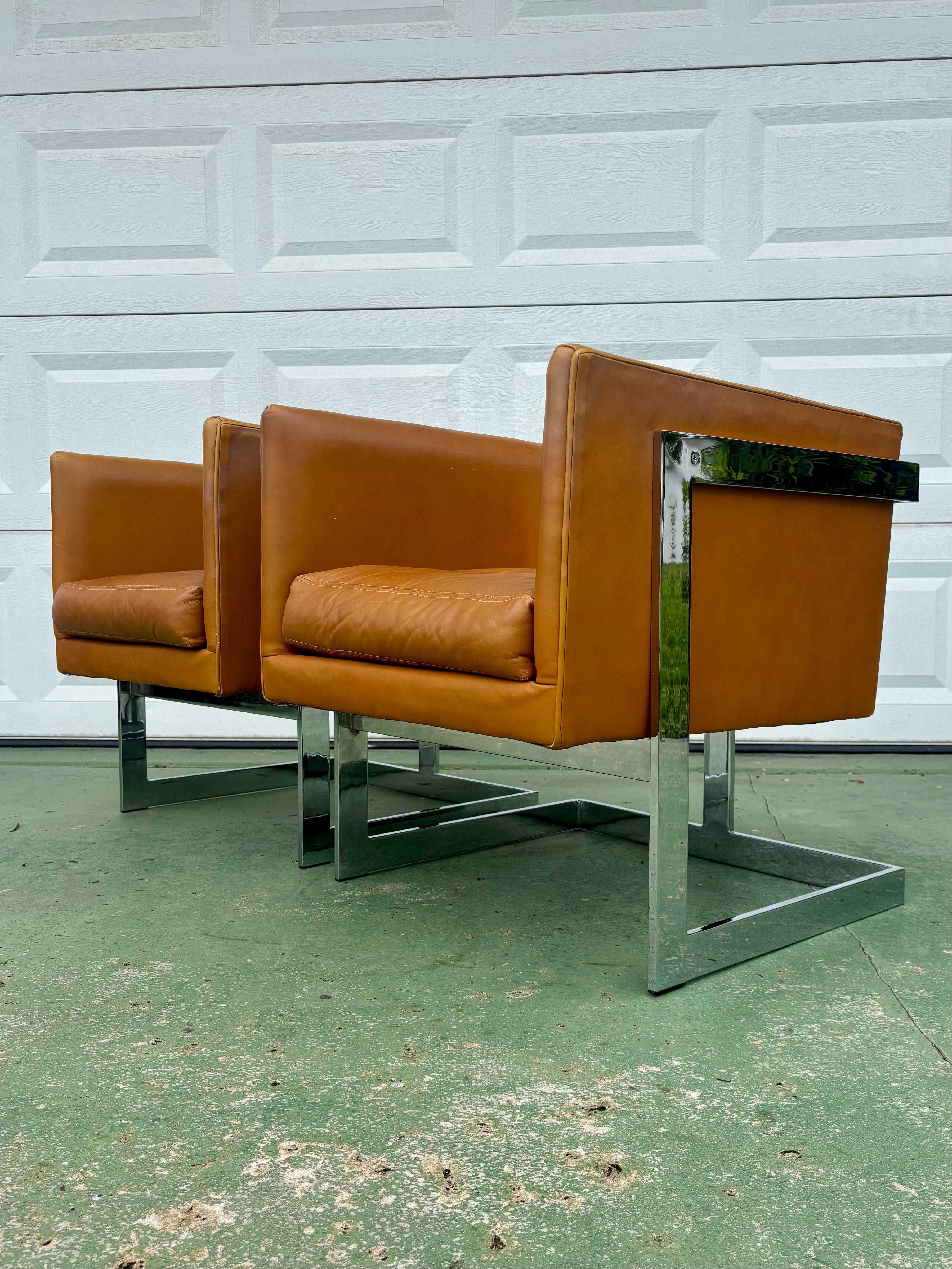 Exceptional pair of cube chairs designed by Milo Baughman for Thayer Coggin. Crisp clean simple lines that define the principles of Mid Century Modern design. One look is all it takes. 

Support their original cognac leather that is just beginning