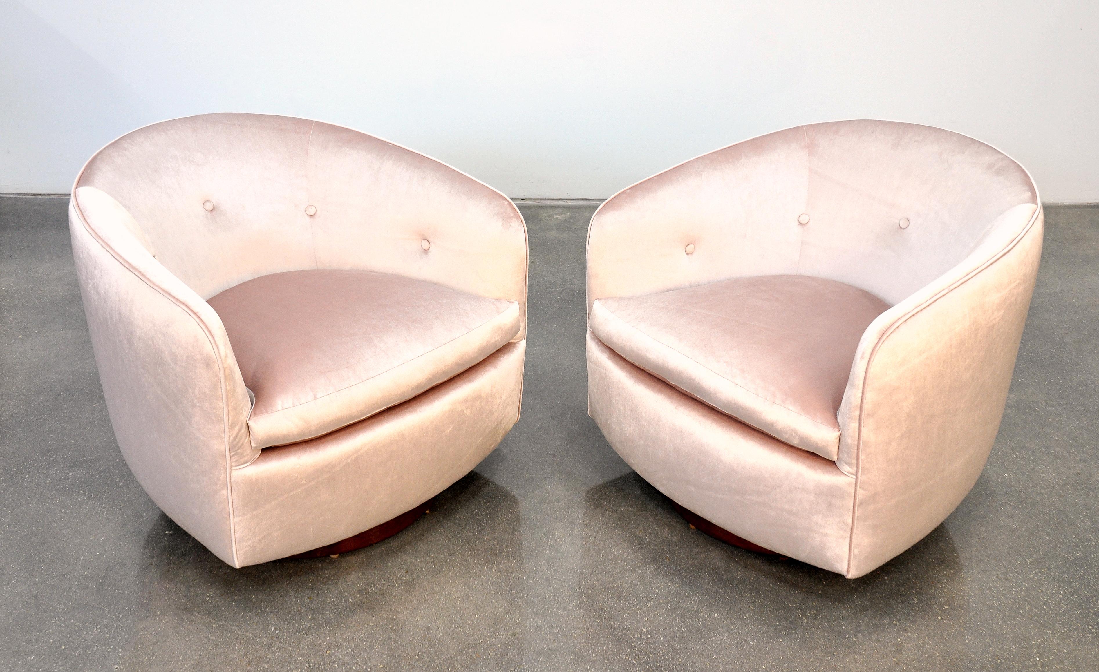 A fabulous pair of Mid-Century Modern tufted barrel back club chairs, designed by Milo Baughman for Thayer Coggin, and dating from the 1960s. Fully restored and reupholstered in a light blush toned pastel rose velvet; featuring walnut bases with
