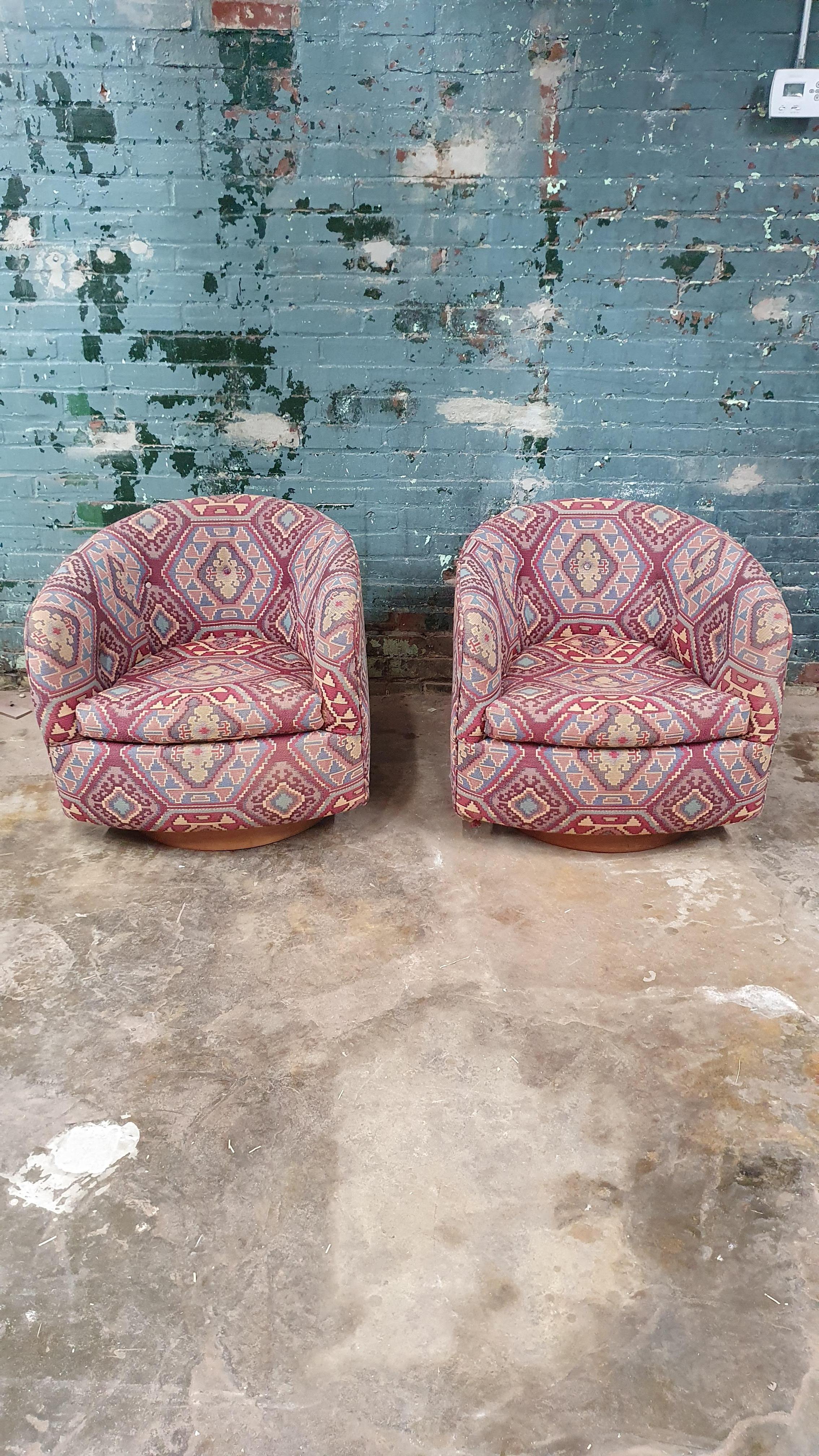 Great vintage pair of swivel tub chairs by Milo Baughman for Thayer Coggin. Round walnut swivel base. the chair swivels 360 degrees and rocks slightly backwards. the upholstery is in great shape and is perfect for someone with eclectic taste or