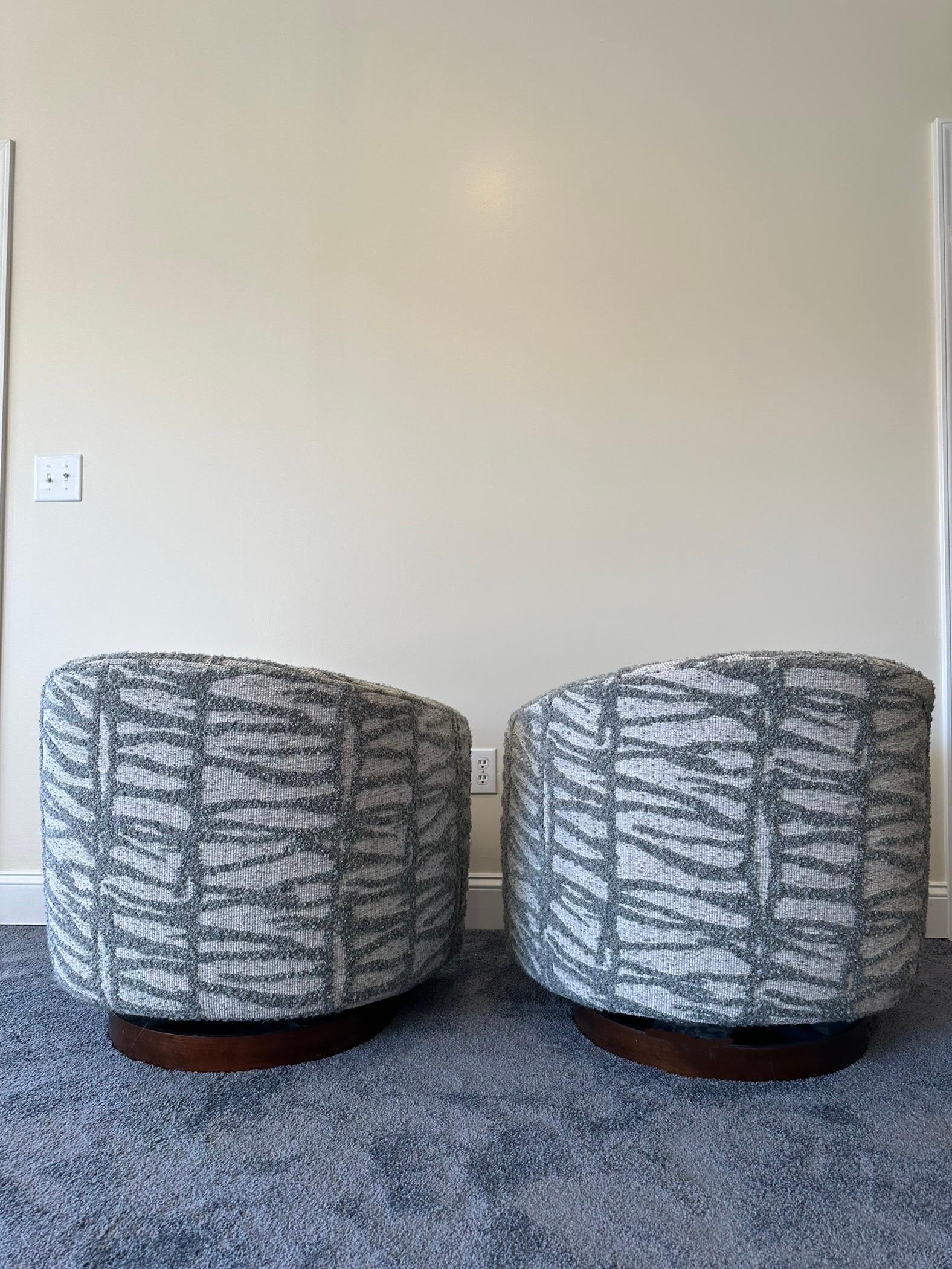 Experience unparalleled style and comfort with this extraordinary pair of swivel and tilt club chairs designed by Milo Baughman for Thayer Coggin. Recently upholstered in a striking geometric textured fabric, these chairs seamlessly blend bold