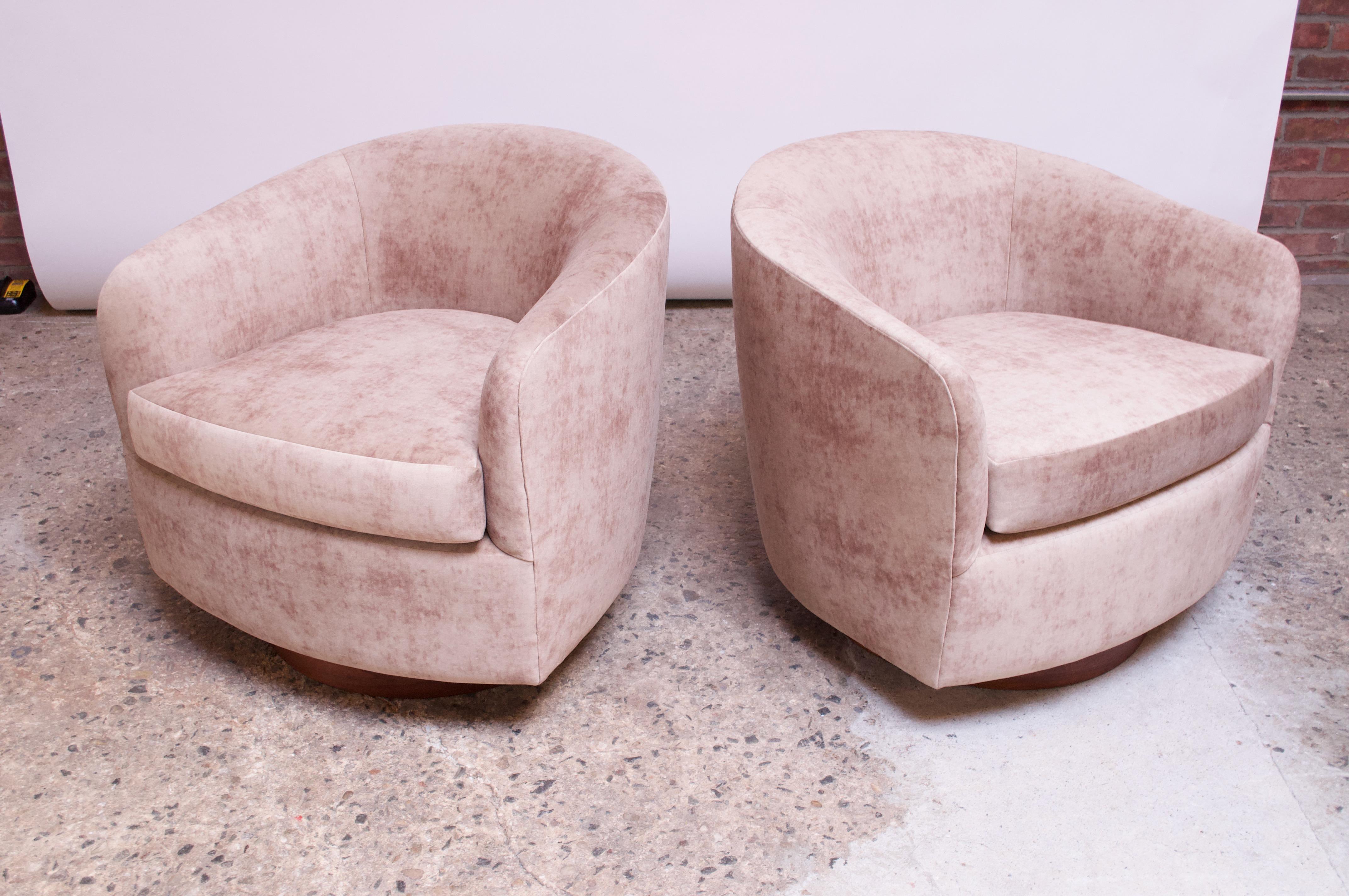 These 1960s Milo Baughman for Thayer Coggin barrel back swivel chairs feature the signature walnut swivel / tilt base. The seats are newly recovered in a mottled blush suede known as 