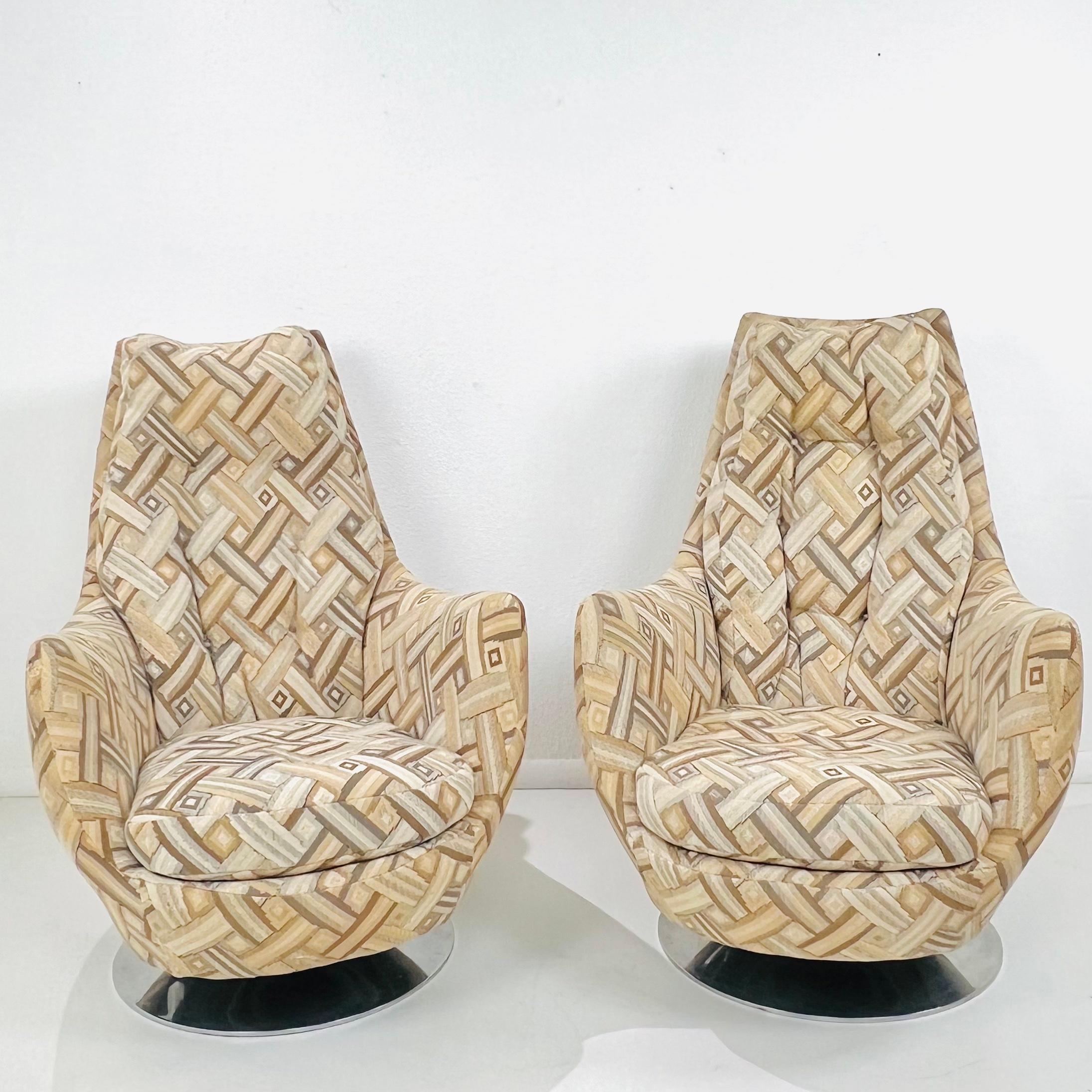 Pair of mid century modern high back club chairs designed by Milo Baughman for Thayer Coggin, with chrome tulip shape bases that swivel and rock. Good structural condition with some imperfections to original upholstery (wear, fading, staining,
