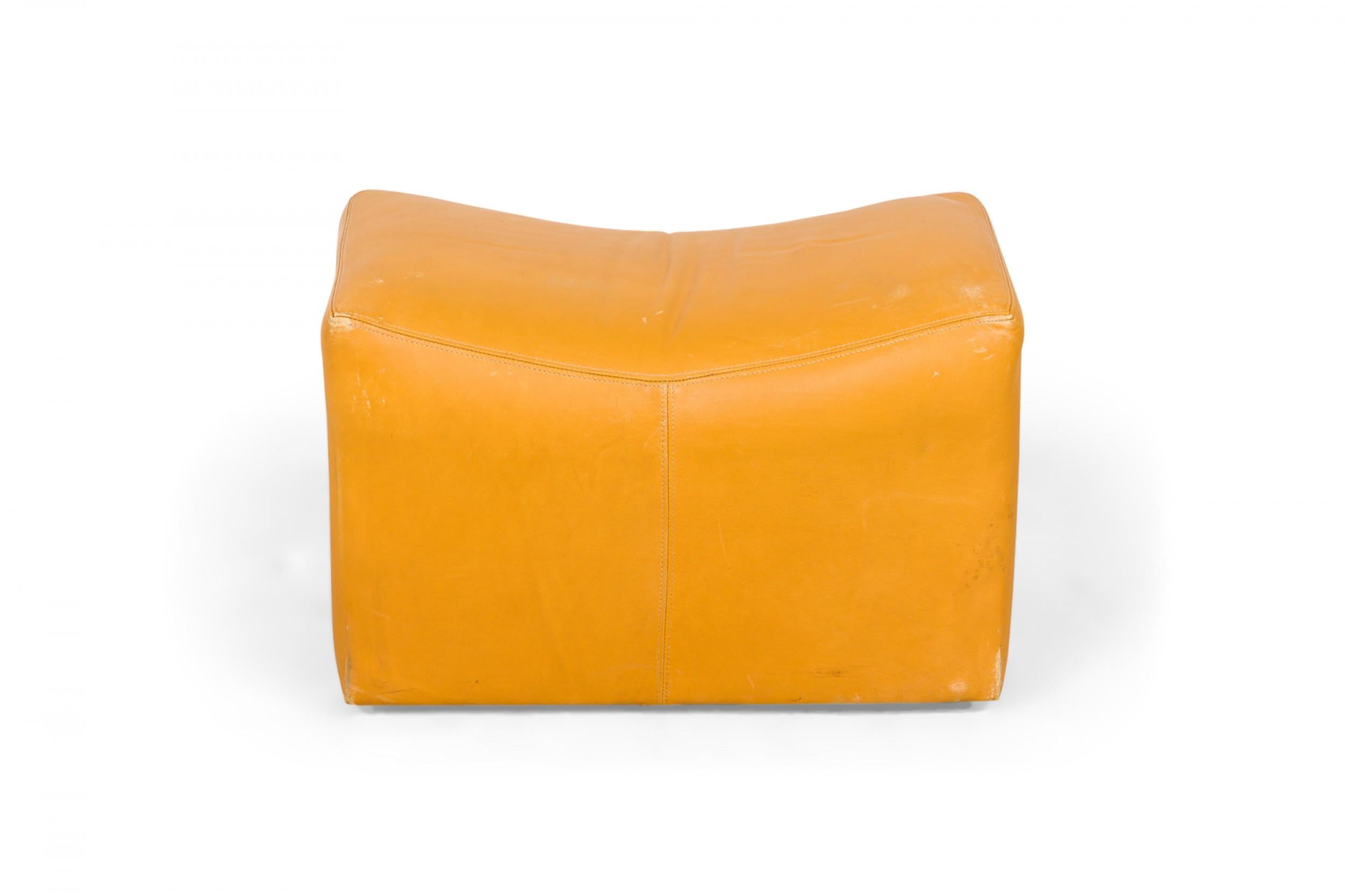 PAIR of American Mid-Century rectangular saddle form ottomans with mustard yellow leather upholstery and scooped tops, resting on four concealed casters. (MILO BAUGHMAN)(PRICED AS PAIR)