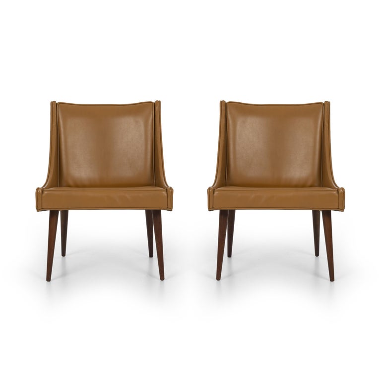 Pair of Milo Baughman slipper chairs for Thayer Coggin, original vinyl upholstery with solid turned walnut legs.
(Multiple labels on underside).