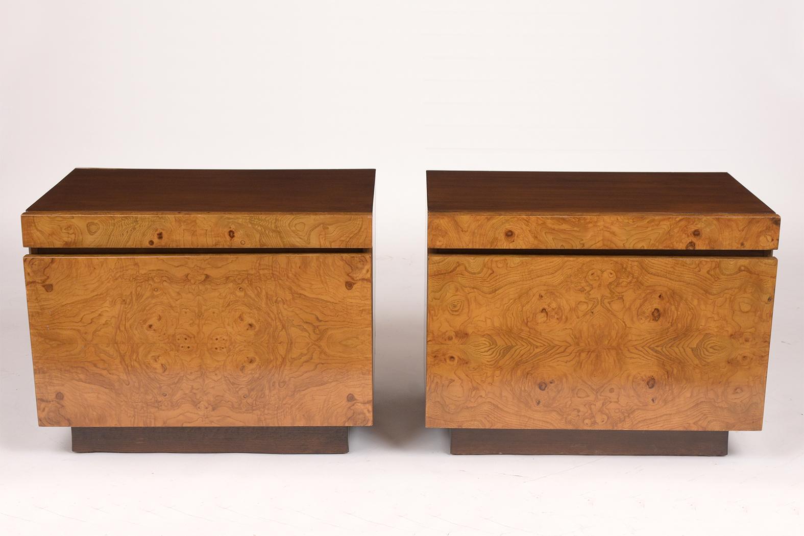 This pair of 1960s Burled Milo Baughman style nightstands are in great condition and feature a newly lacquered finish. The pair has a walnut colored frame and the two pull-outs are covered in a rich oak colored veneer. They also come with a pull-out