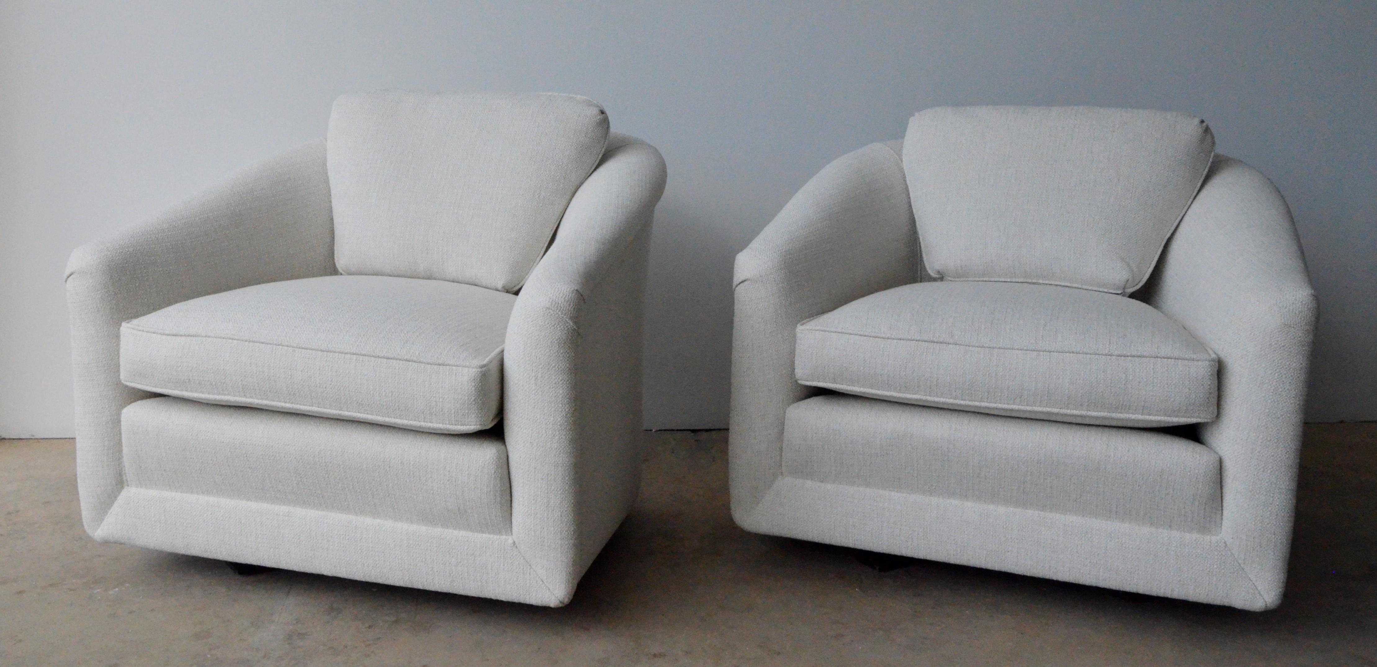Offered is a pair of Mid-Century Modern Milo Baughman style swivel chairs with non-exposed wood base and back cushion in newly upholstered creamy white tweed. This pair of swivel chairs exudes luxury in style, material and color. The comfort and