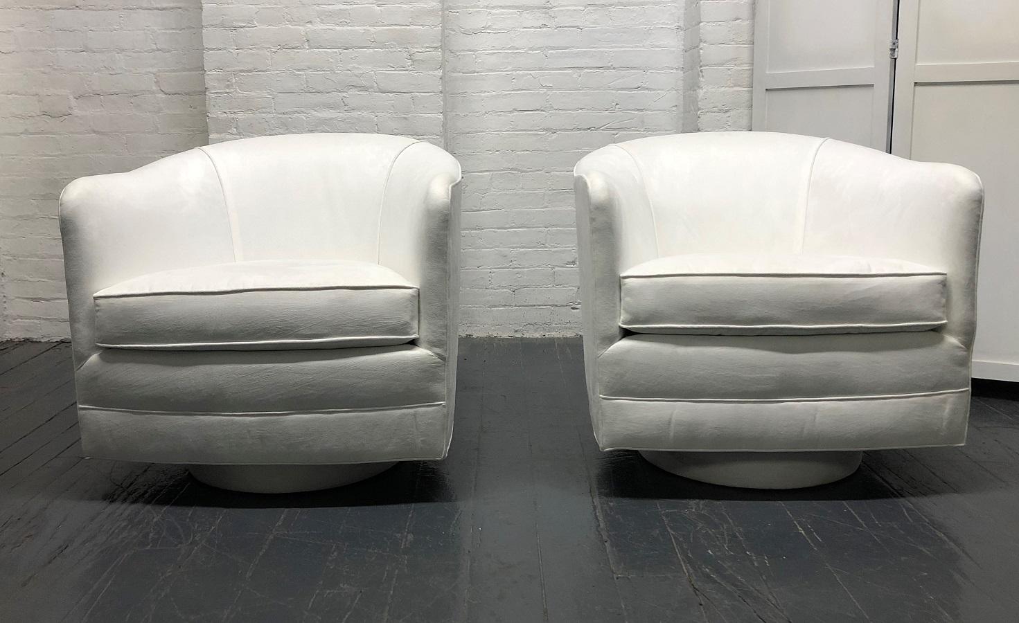 Pair of Milo Baughman style swivel lounge chairs. The chairs swivels 360 degrees. Beautiful pure white ultra suede upholstery.