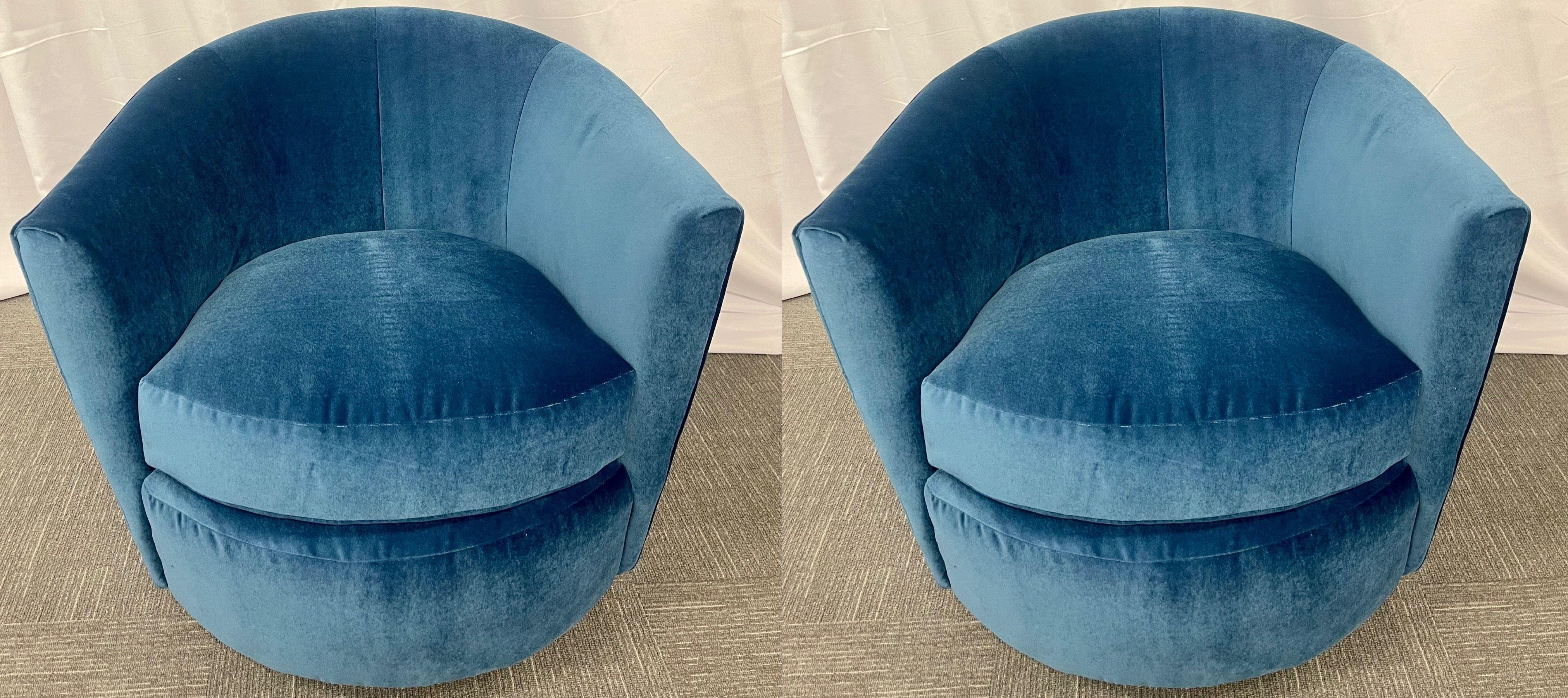 Pair of Milo Baughman style swivel, tub chairs, blue velvet, American, 1980s.

These stylish tub, swivel or arm chairs reminiscent of the Kagan style and design each have a Blue Velvet fabric accompanied by matching cushions and steel swivel