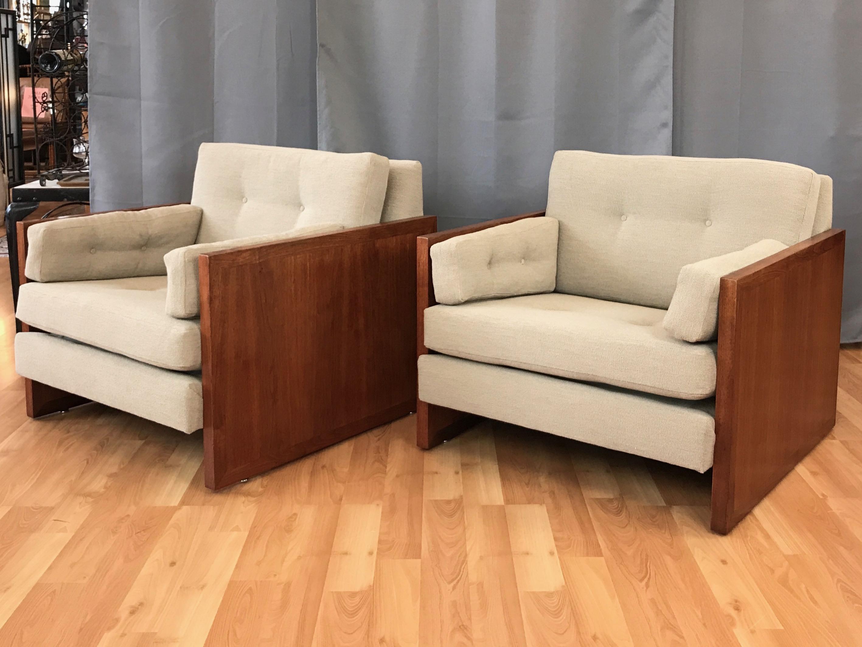 An exceptionally handsome pair of vintage walnut cube lounge chairs in the style of Milo Baughman.

Cased sides of bookmatched walnut with flush frame border detail support a comfortably canted seat and back. Tufted cushions freshly reupholstered