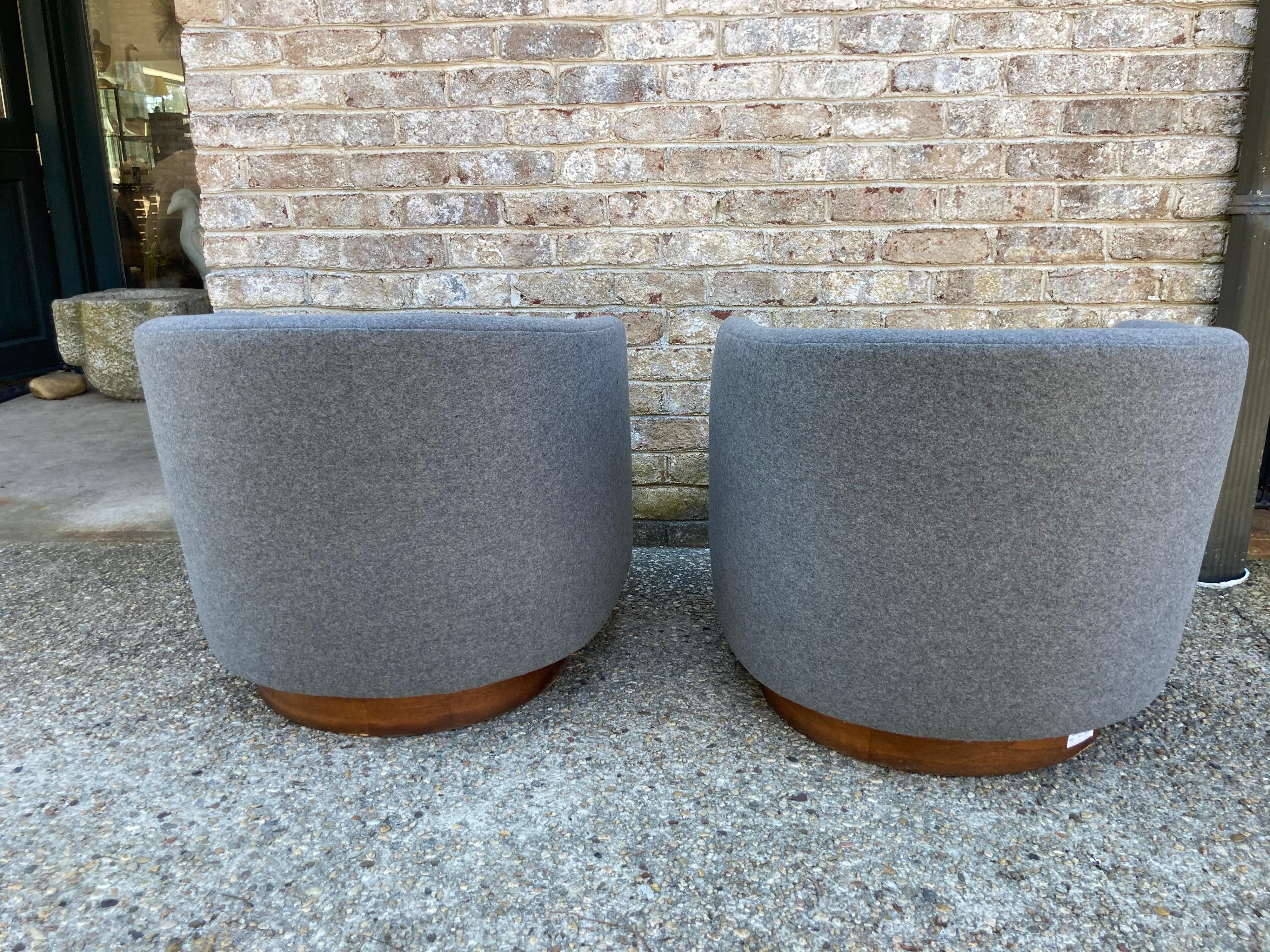 Newly reupholstered and restored pair of Milo Baughman swivel chairs. gray wool flannel.