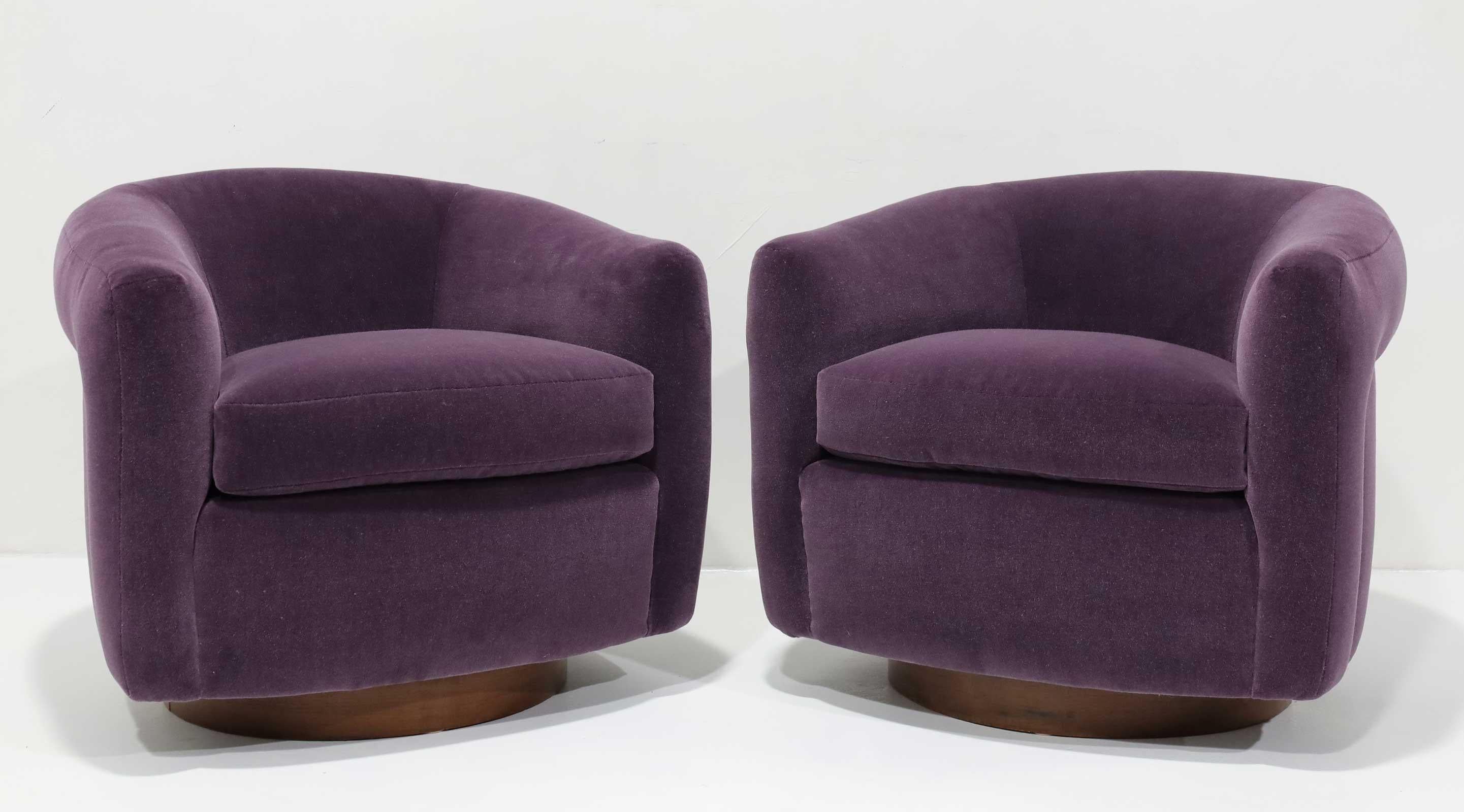 A beautifully restored pair of Milo Baughman swivel chairs with walnut base and newly upholstered in an eggplant mohair by Maharam. 