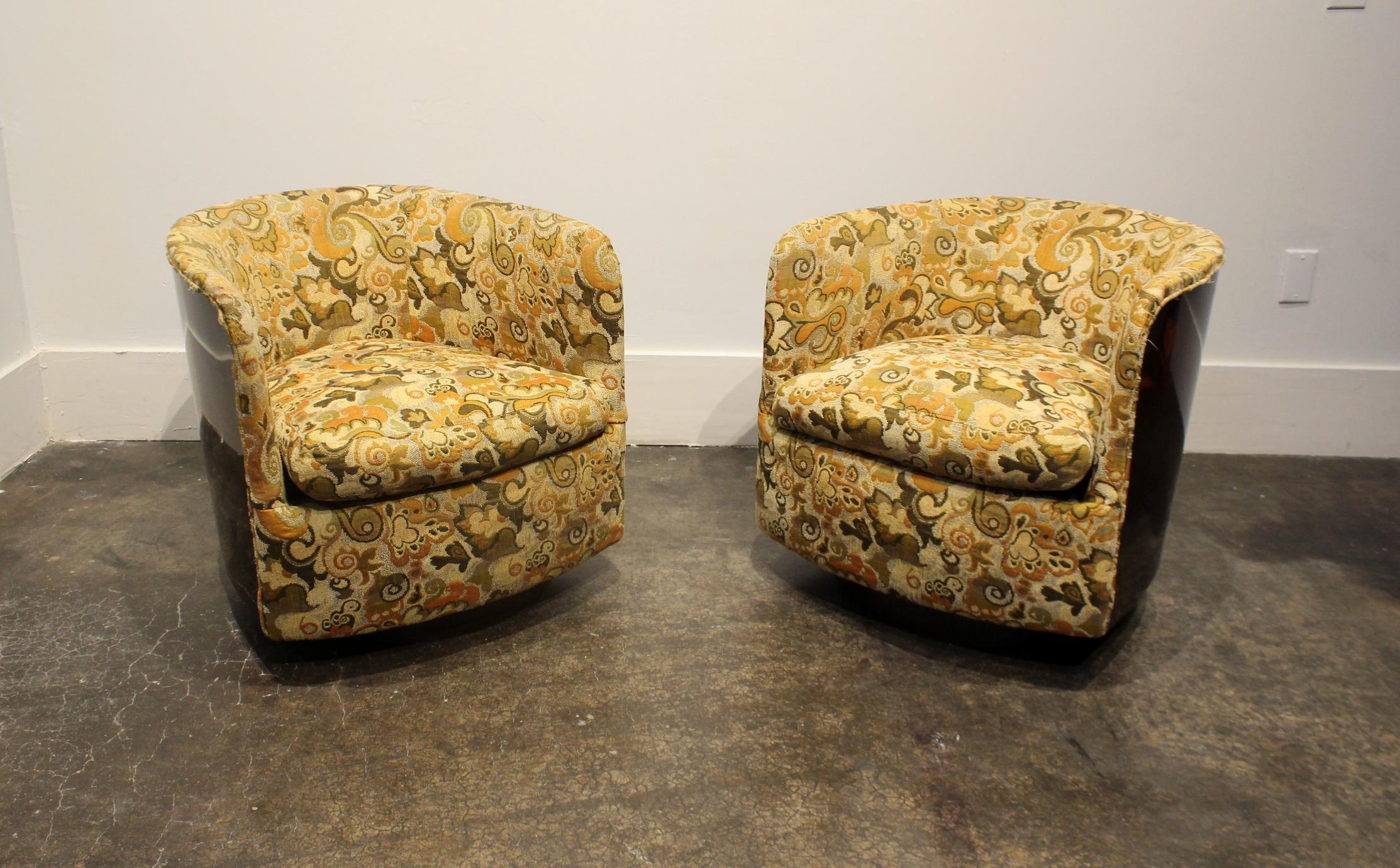 Pair of Milo Baughman for Thayer Coggin swivel tub chairs from 1972 with original tags and upholstery. Brown laminate wraps around sides and back. Floral upholstery in tan, yellow, orange, green and brown.
 
  