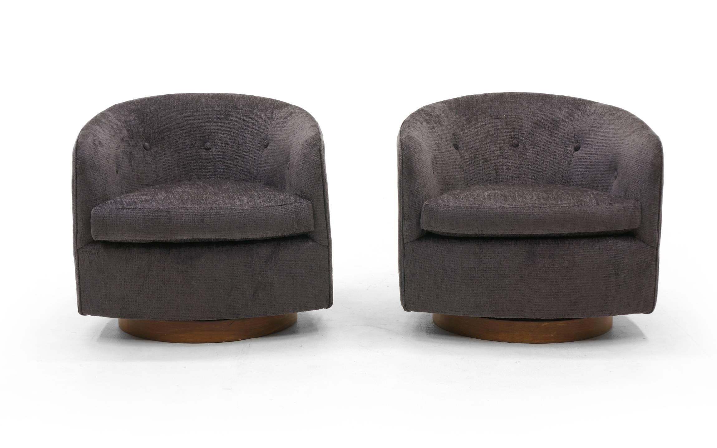 Stunning pair of Milo Baughman for Thayer Coggin's tilt and swivel even arm barrel chairs on walnut bases. These have been completely restored, refinished, and reupholstered in a beautiful, soft, charcoal grey Robert Allen Chenille fabric. The