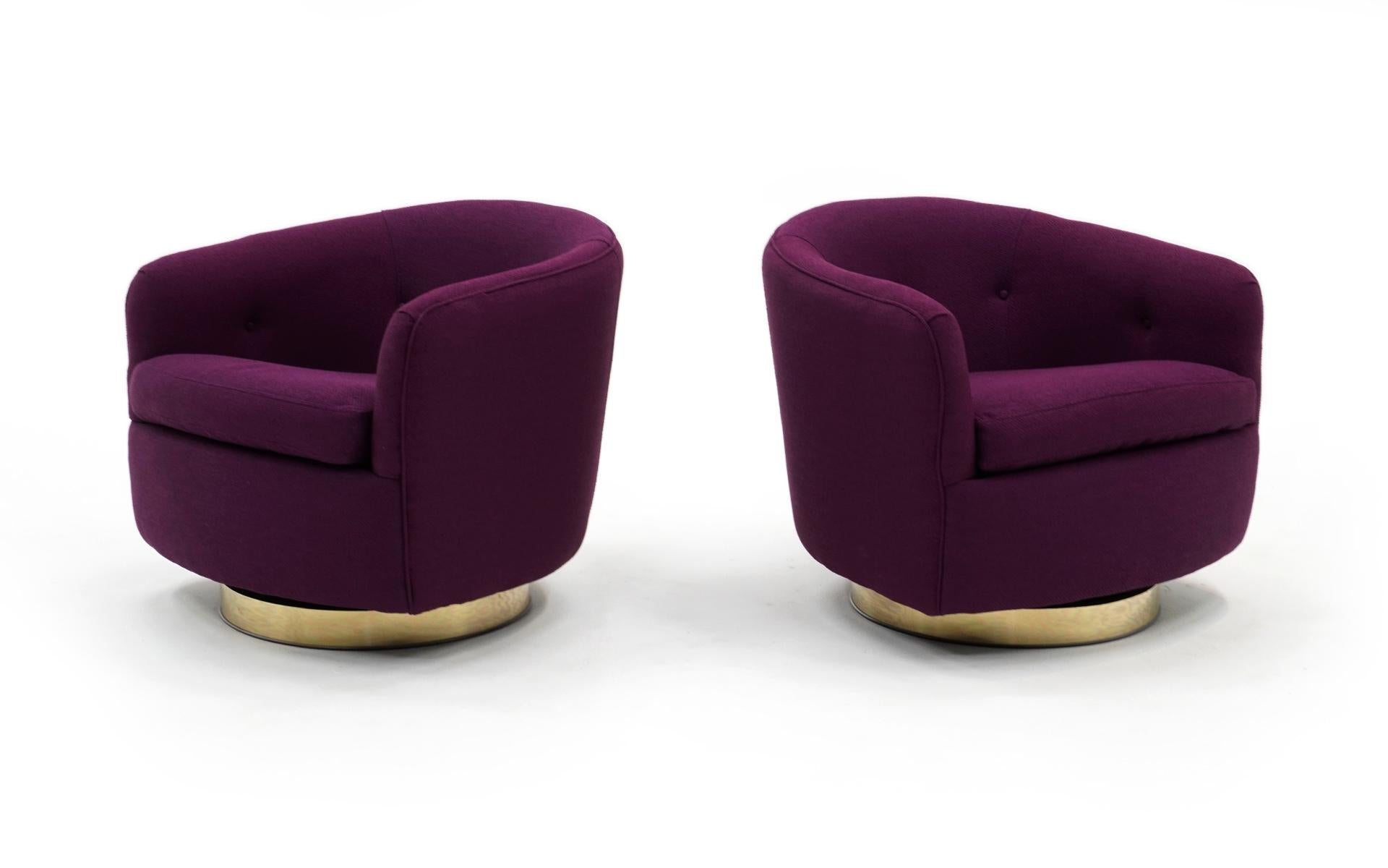Stunning pair of Milo Baughman for Thayer Coggin tilt and swivel even arm barrel chairs on brass bases. These have been completely restored and reupholstered in a beautiful purple Maharam fabric. Bases may show minimal wear, but only upon close