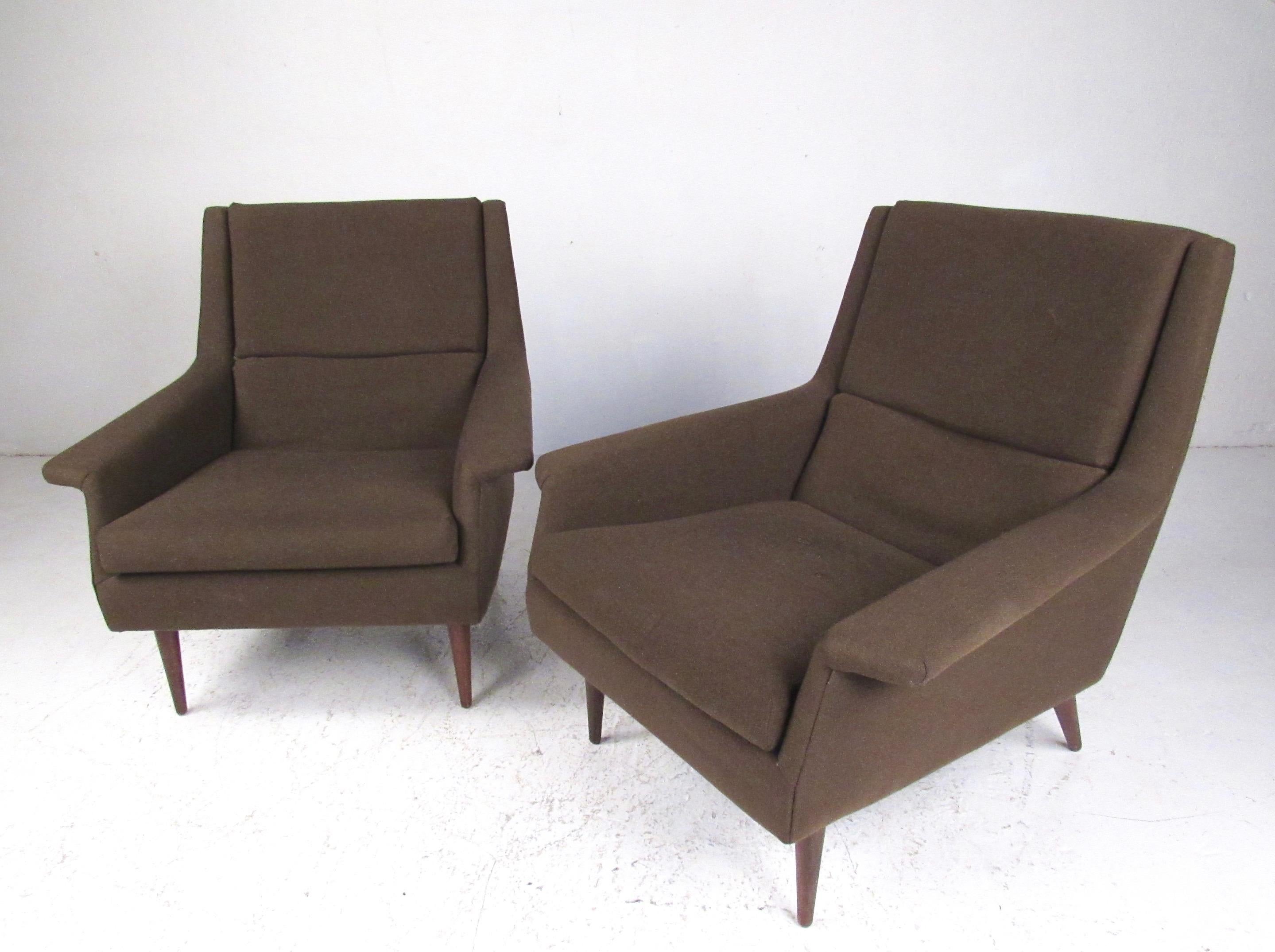 This stylish pair of matching Mid-Century Modern lounge chairs feature timeless Milo Baughman design for Thayer Coggin. The tapered vintage walnut legs and shapely seat frames are perfectly complimented by the uniquely angled armrests. Iconic design