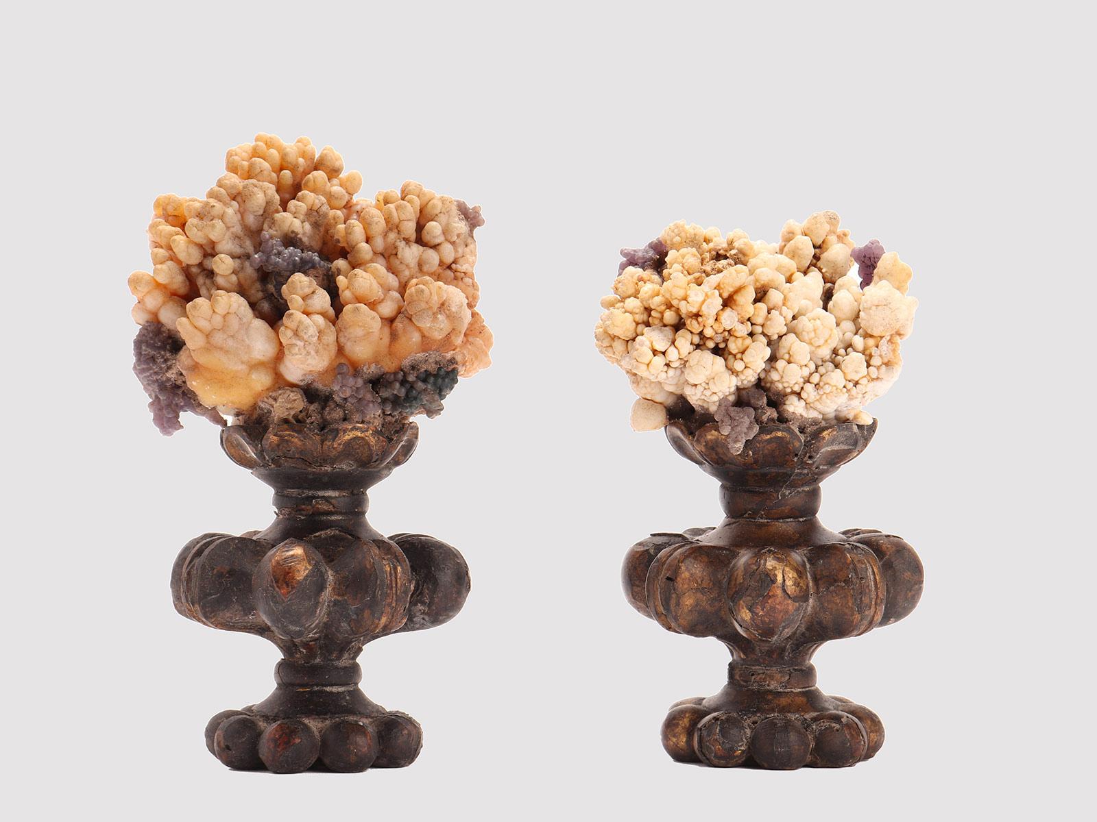 A Pair of Naturalia mineral specimen: Calcite flowers and Pyromorphite crystals, mounted over a carved wooden base, vase shape, gold gilded. Italy around 1880.