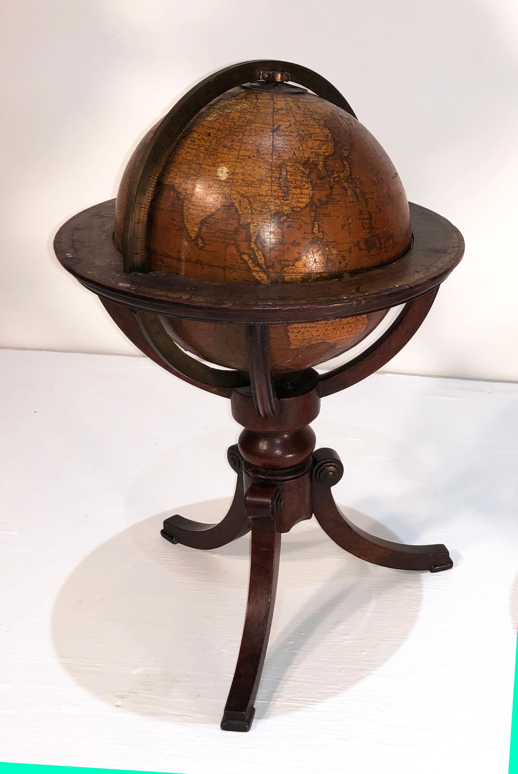 Magnificent pair of miniature 19th century globes on mahogany Regency Stand. Both globes are labeled by Newton and Sons. The Globes are mounted on Classic Regency pedestals.