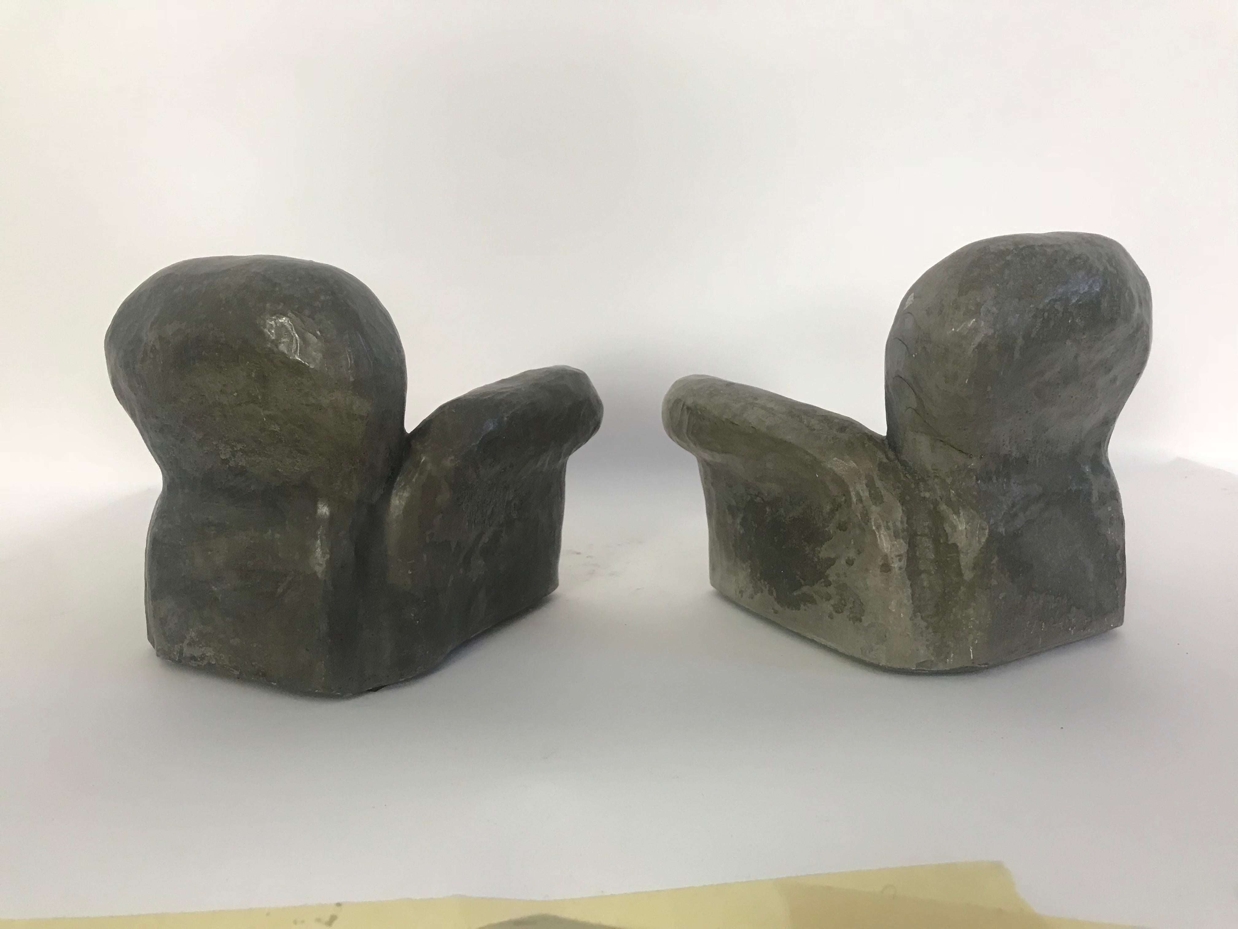 This is a pair of ceramic sculptures in the form of two miniature lounge chairs.